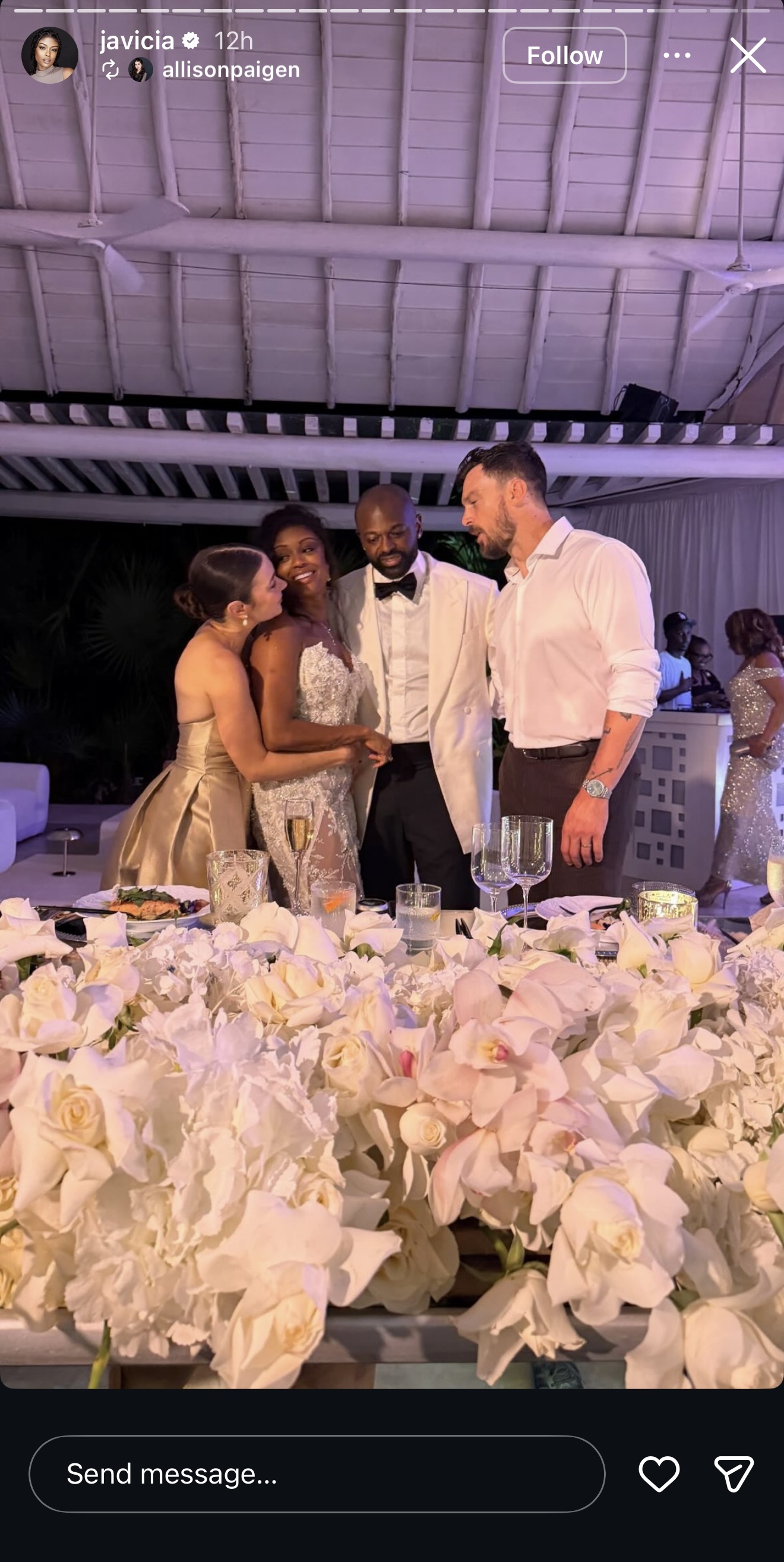 Javicia Leslie's groom, Nana-Yaw Asamoah, now wears a white tuxedo jacket and bow tie, while Javicia leans in warmly toward a guest. | Source: Instagram/javicia