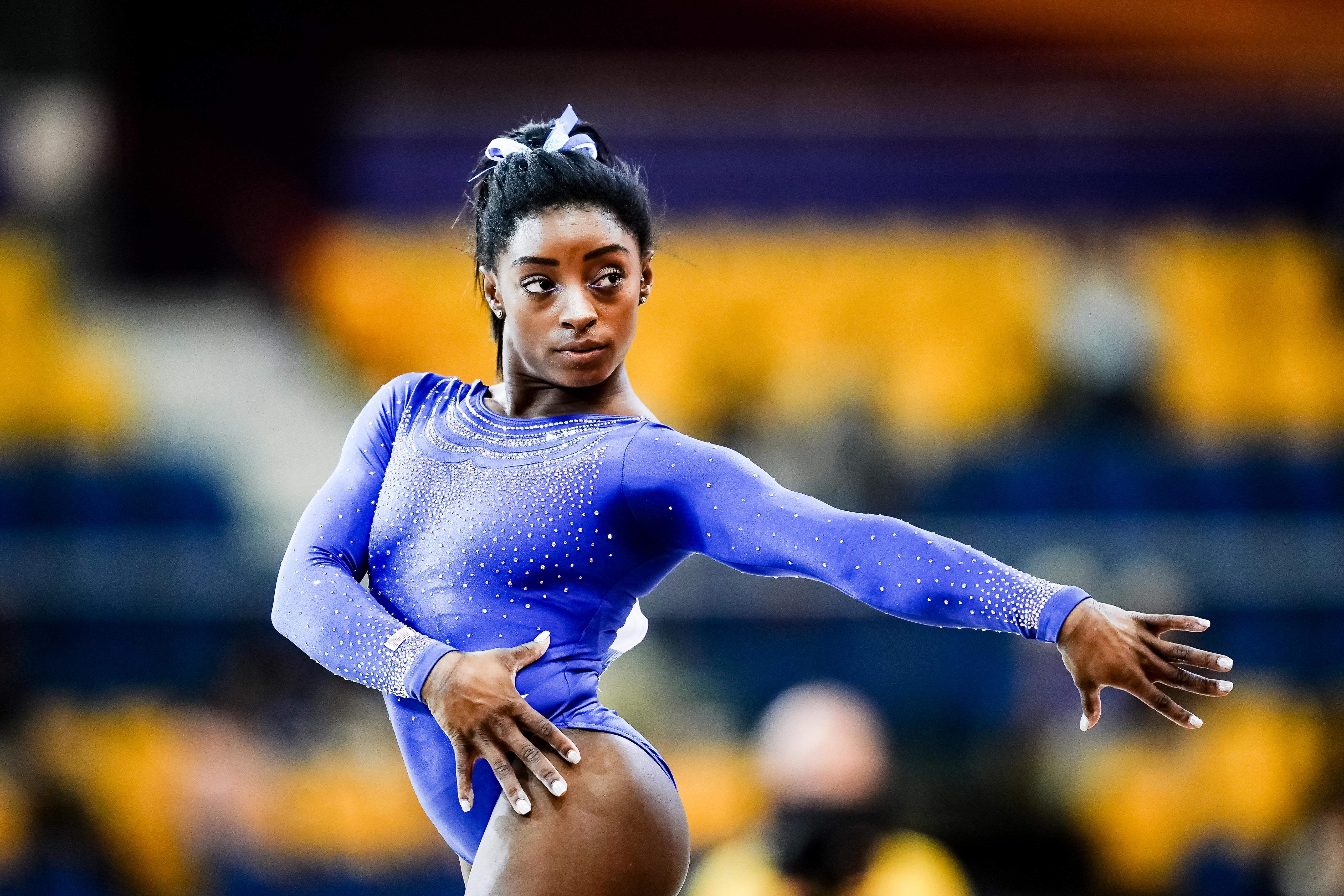 Mid-routine and laser-focused, Simone Biles strikes a powerful pose during floor qualification in Doha on October 27, 2018, capturing the grace and grit that define her legacy.