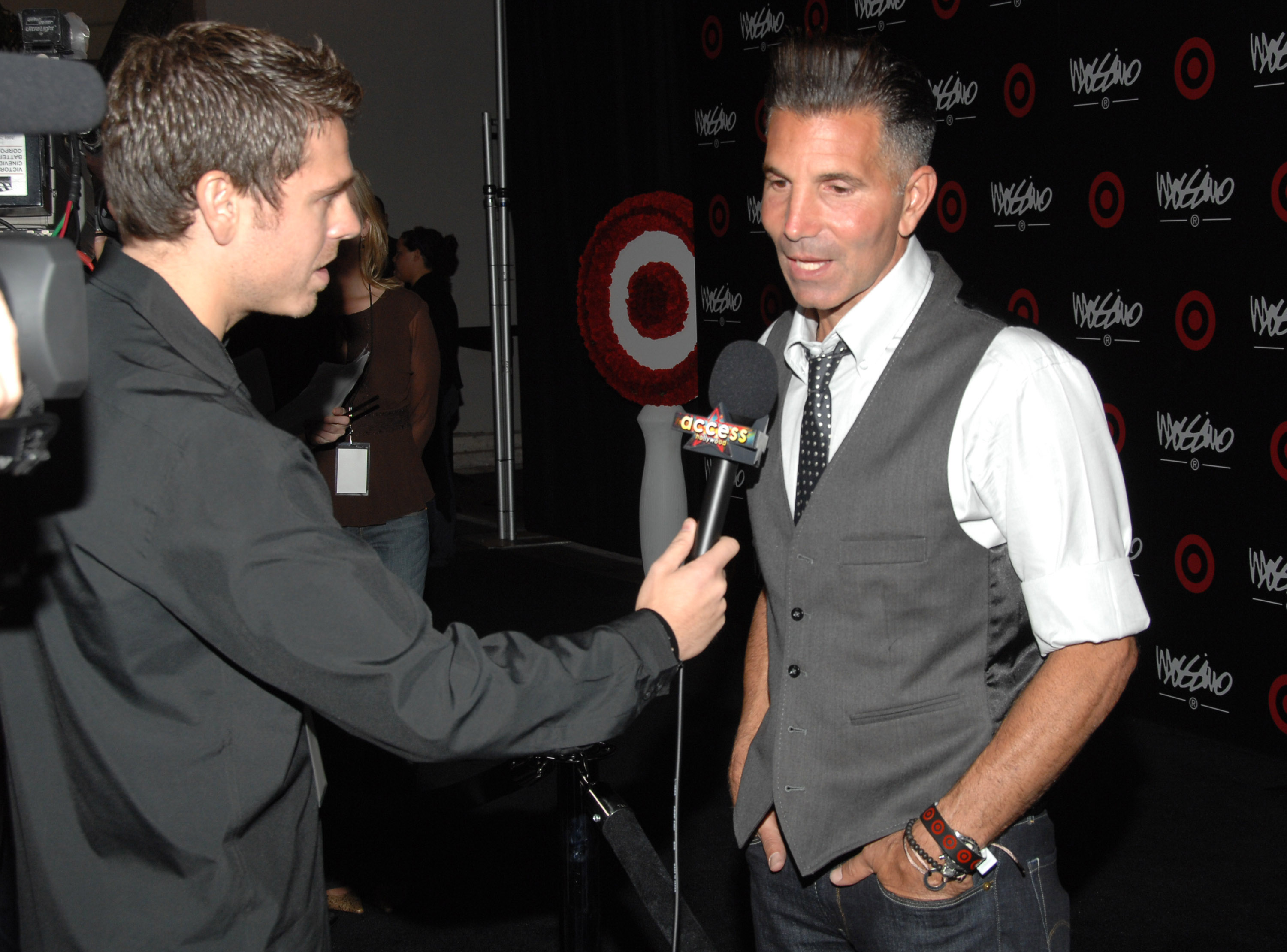Mossimo Giannulli speaks with a reporter at a Los Angeles Fashion Week party for his namesake brand. His fashion career gave the couple a second source of high-profile success outside Loughlin's work in Hollywood. | Source: Getty Images