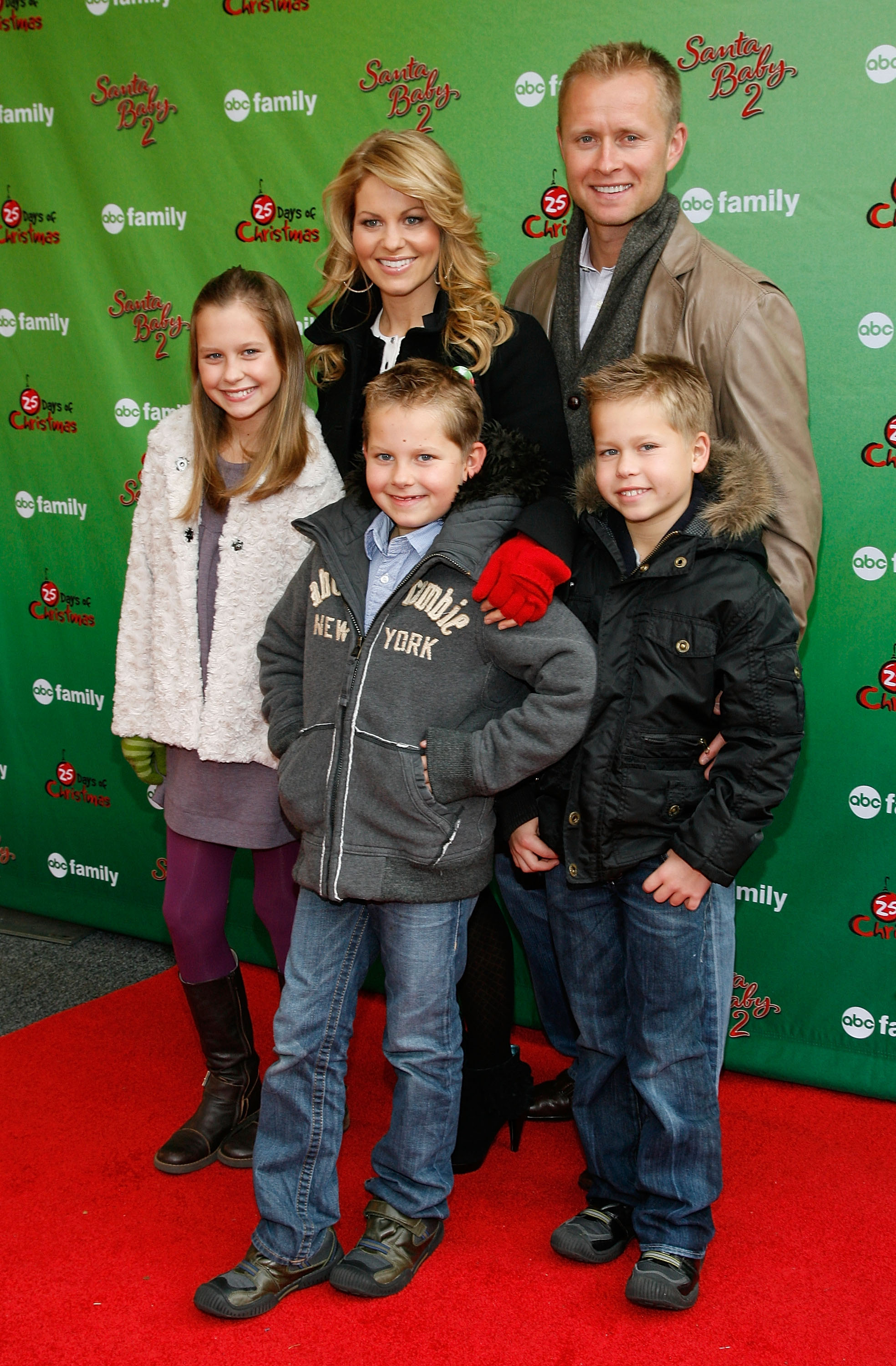 Candace Cameron Bure steps out with her family—husband Valeri Bure and children Natasha, Lev, and Maksim—at the ABC Family World Record Elf Party at Bryant Park in New York City on December 7, 2009. The festive group bundled up for the winter red carpet, with young Maksim smiling in a black hooded winter parka and blue jeans beside his older brother Lev in a grey fleece jacket and sister Natasha in a cozy white vest and purple tights. | Source: Getty Images
