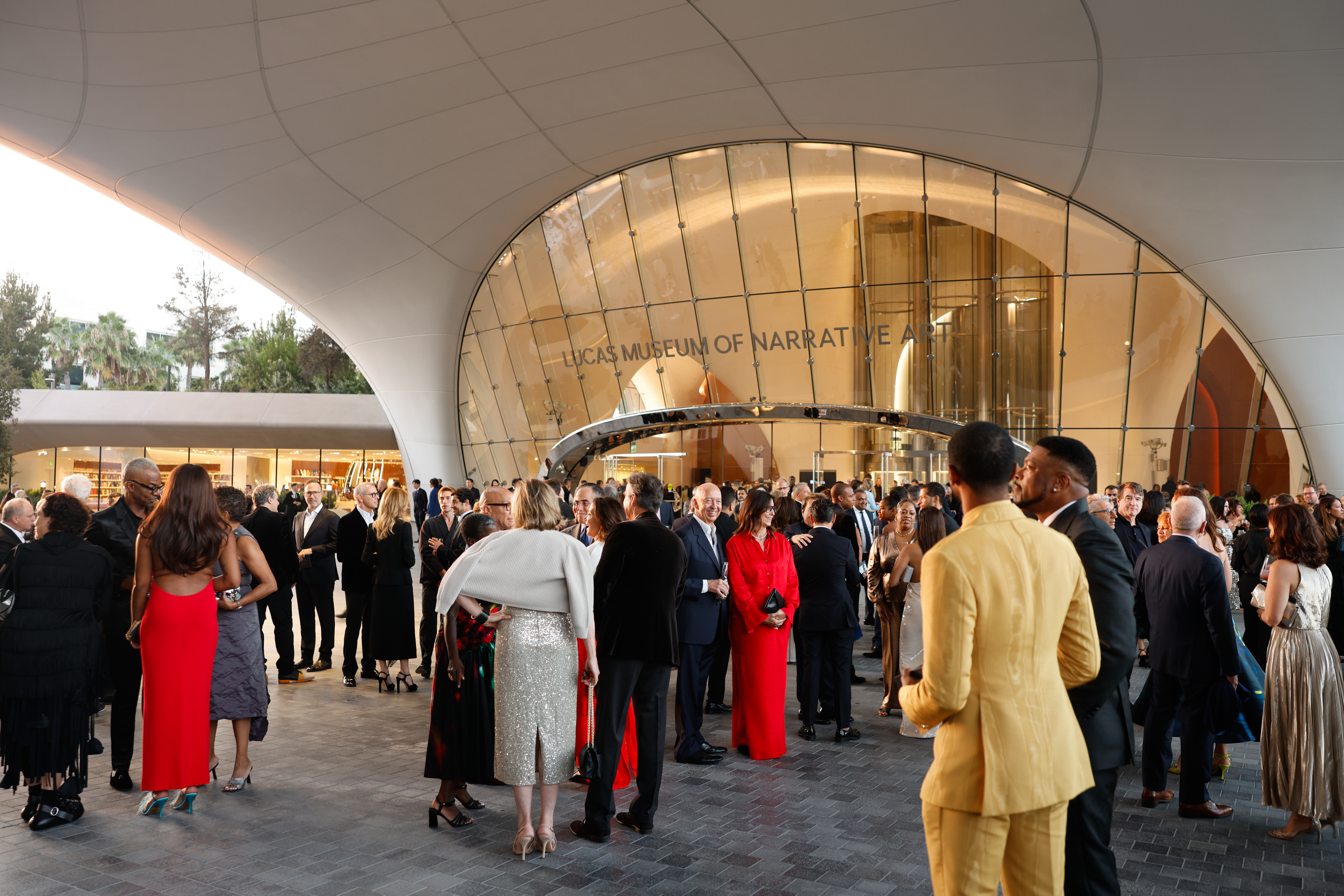 Guests gathered beneath the museum's sweeping exterior as the opening-night celebration continued. The wide view captured the crowd outside the glass-fronted entrance and offered a closer look at the building's curved architecture. | Source: Getty Images