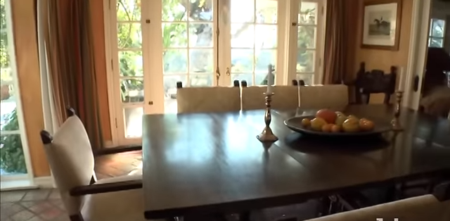 The expansive dining table sits fully set with simple candelabra and a fruit centerpiece. | Source: YouTube/@Biography