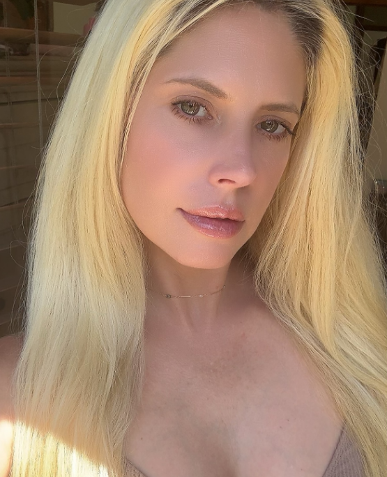 Basking in warm golden-hour light, Cleo Rose Elliott treated followers to a stunning close-up selfie uploaded to Instagram on June 30, 2026. She gave a faint, knowing smirk straight into the lens, rocking sleek platinum-blonde hair parted down the middle, a fine gold chain around her neck, and a ribbed neutral strap top paired with dewy, soft glam makeup.