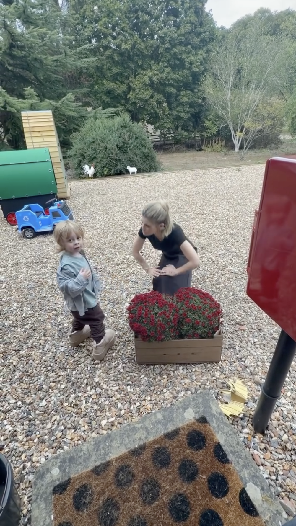 In one affectionate photograph, Sidney wraps his arms around Kelly while she wears a fluffy gray rabbit hat. Other footage shows the little boy exploring outdoors near a planter of red flowers while his mother stays close. | Source: Instagram/@kellyosbourne