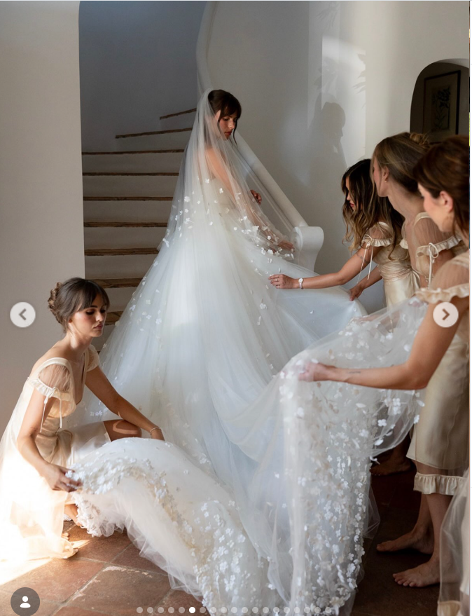 Paula stood on a curved staircase as her bridal party carefully arranged her sweeping, flower-dotted veil and train around her ahead of the ceremony. | Source: Instagram/babybruss