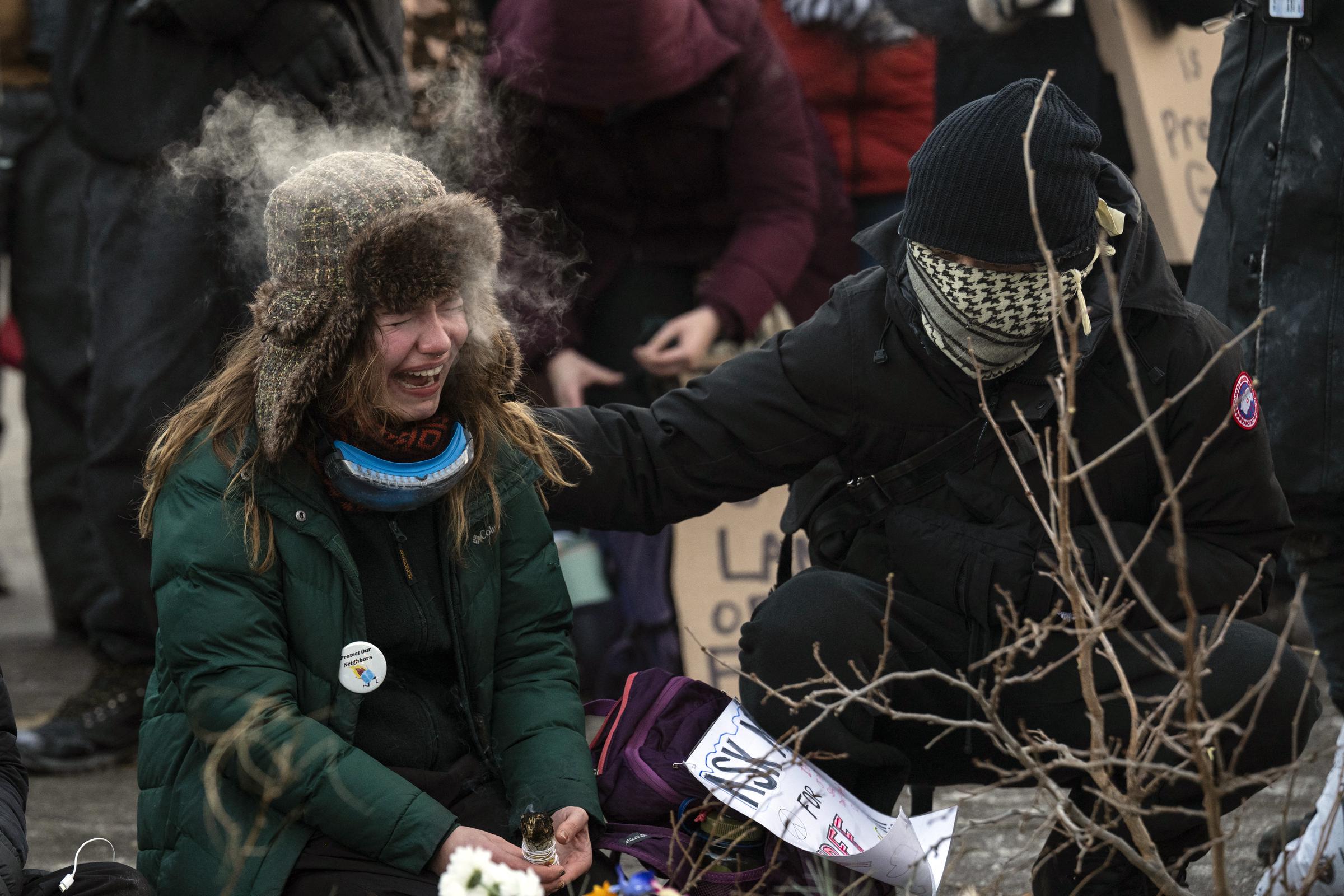 A woman cries at a makeshift memorial in the area where Alex Pretti was shot dead by federal immigration agents in Minneapolis, Minnesota, on January 24, 2026. | Source: Getty Images