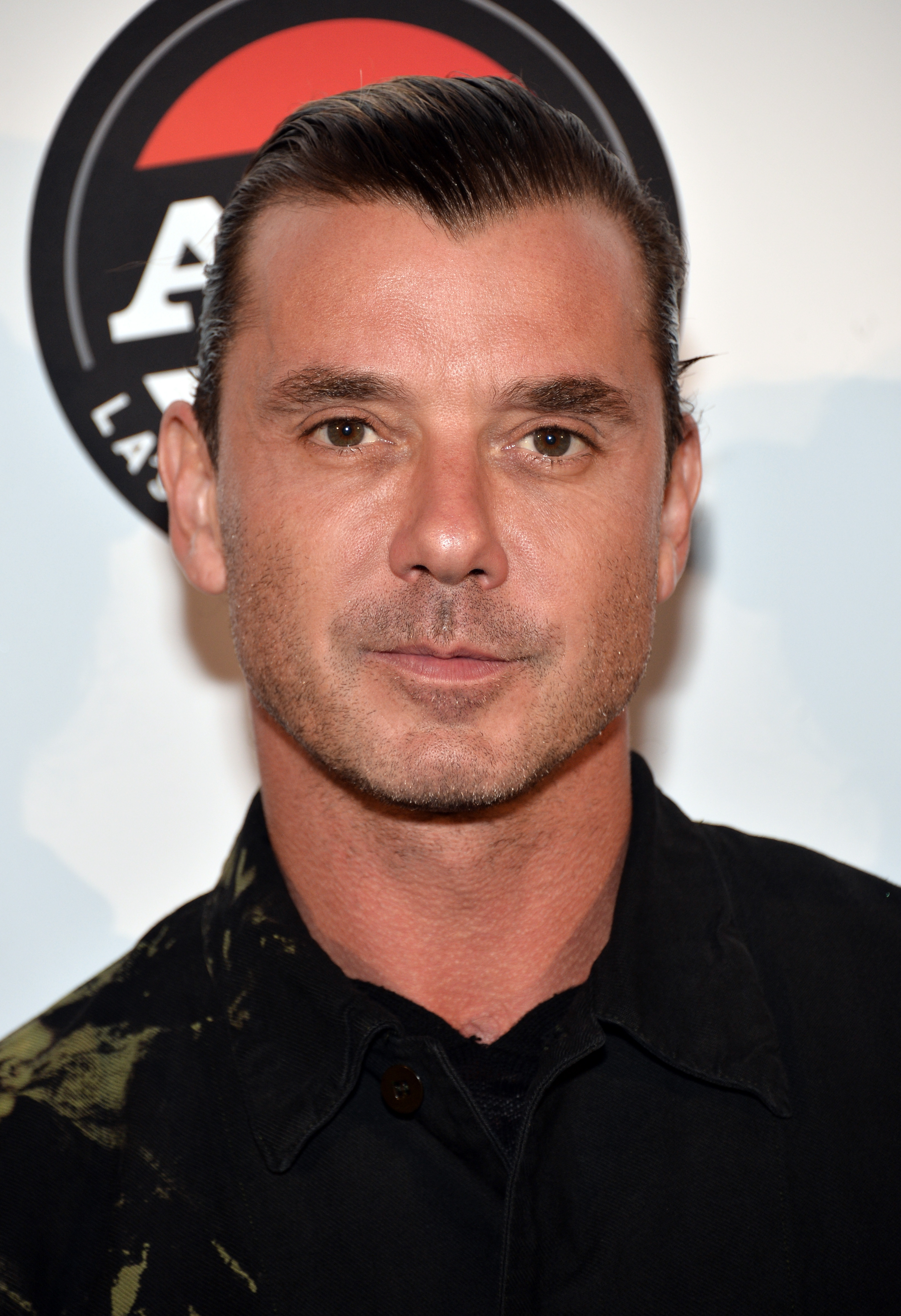 Gavin Rossdale poses before Bush's Alt 98-7 rooftop performance in Hollywood, his hair neatly swept back as he wears a dark patterned jacket.