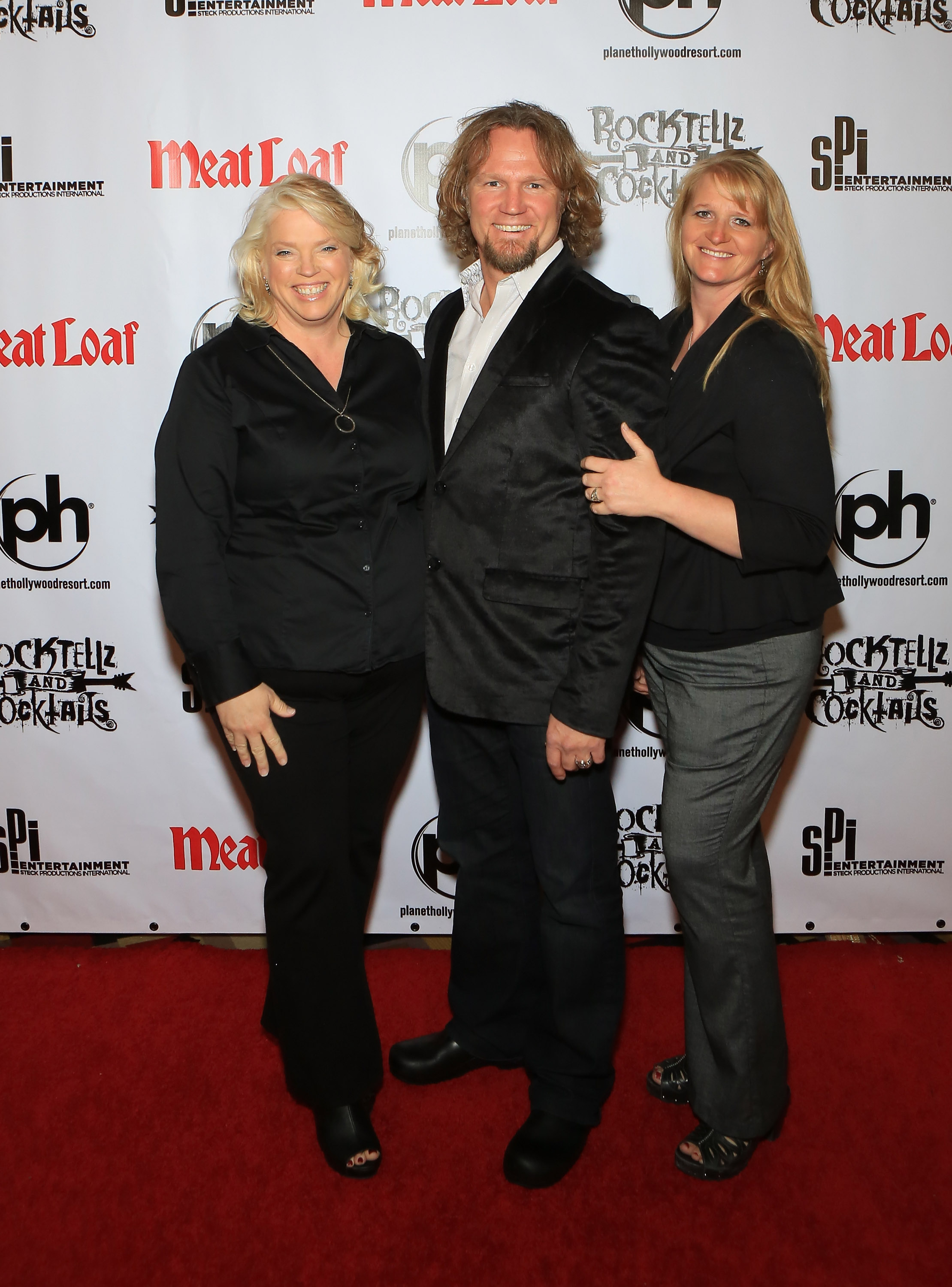 Janelle, Kody, and Christine Brown smile together at a Las Vegas event in 2013, years before both women ended their spiritual marriages to the "Sister Wives" patriarch. | Source: Getty Images