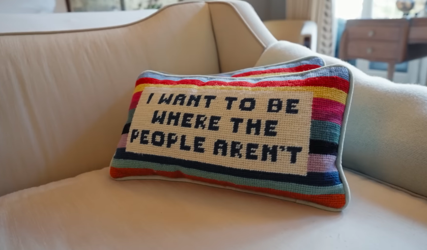 The cheeky pillow gives the polished suite a wink of personality. It is a tiny but revealing detail in a very carefully designed home. | Source: YouTube/Architectural Digest