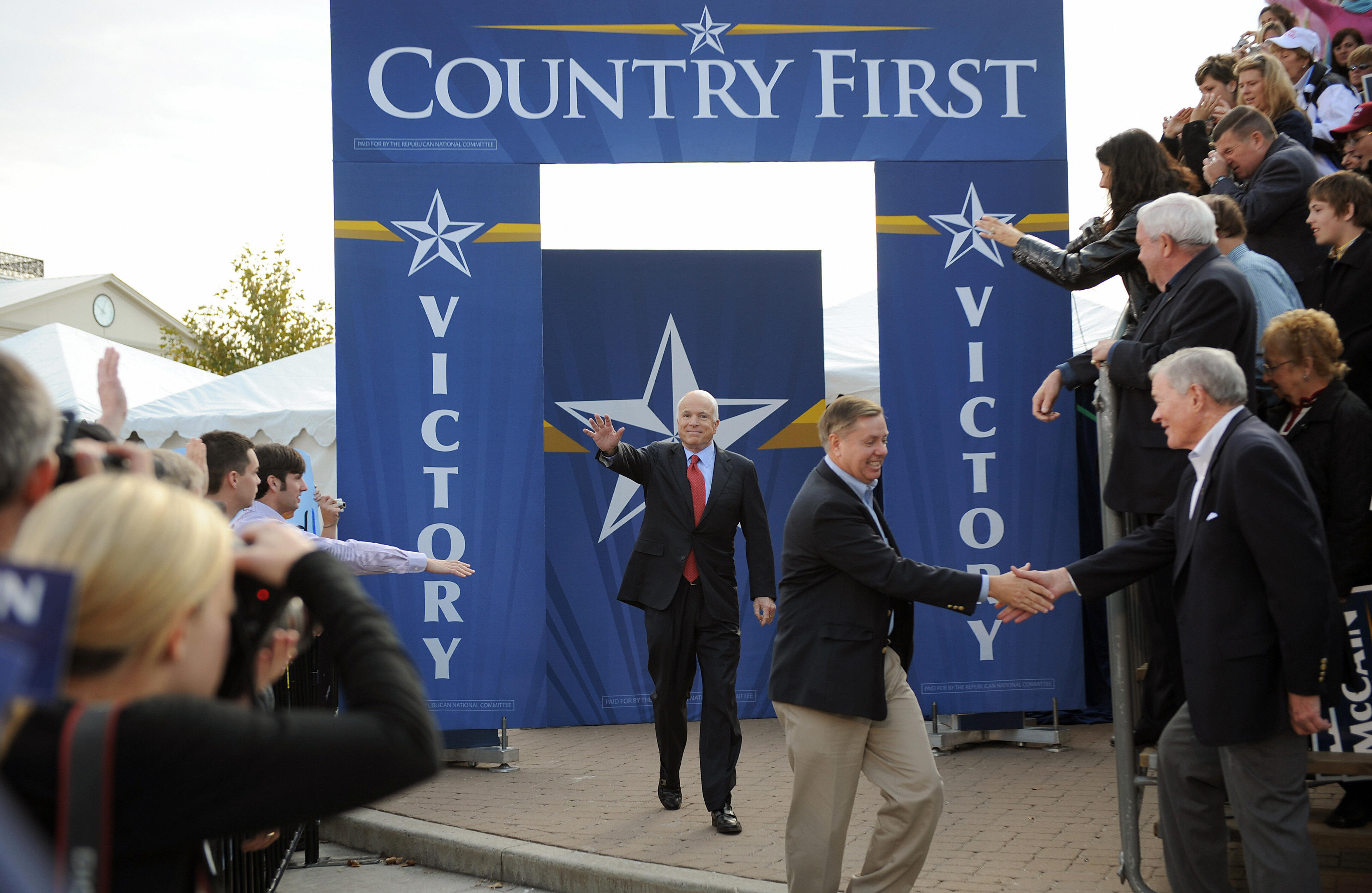 Walking alongside Republican presidential nominee John McCain before a campaign rally, Lindsey Graham greets supporters as the two crisscross the country during a pivotal election season. The appearance highlighted Graham's role as one of McCain's closest allies and advisers. | Source: Getty Images