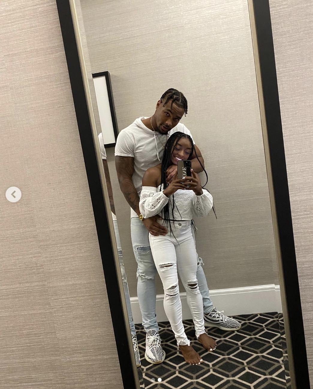 Jonathan Owens shared this mirror selfie with Simone Biles in September 2020. In the photo, the couple poses closely, with Owens standing behind Biles and wrapping an arm around her waist. Biles smiles while holding up her phone to capture the moment, both dressed in casual white and denim outfits.