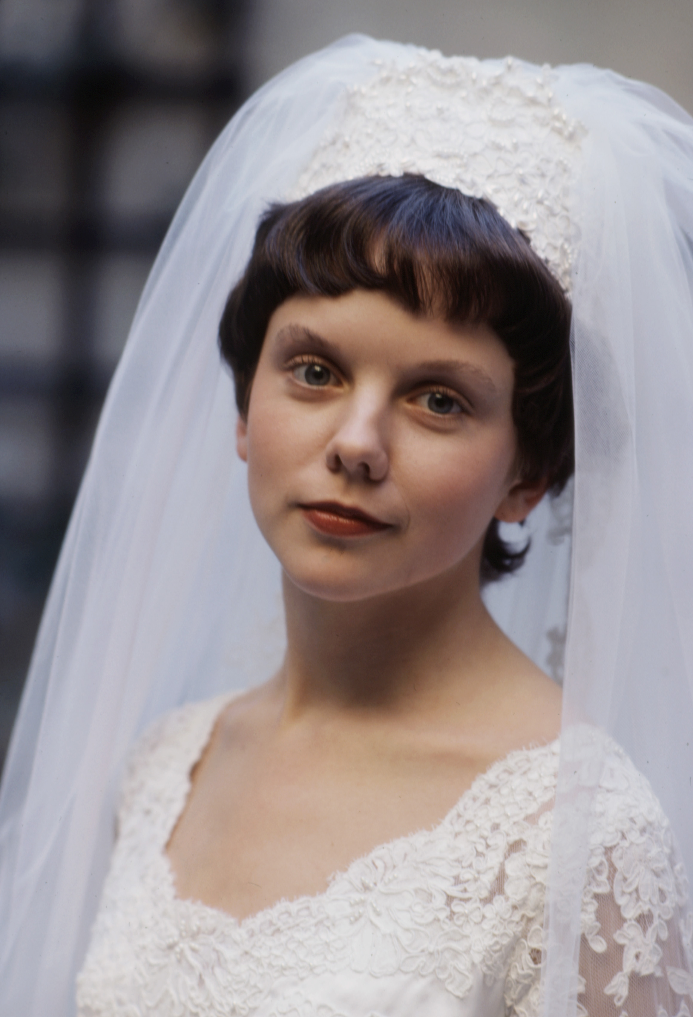 Framed by an intricate lace veil, 23-year-old Linda Purl looked remarkably delicate sporting a dramatic, dark pixie cut with short fringe for the 1979 TV movie "Like Normal People". A rich crimson lip and wide-eyed expression offset the delicate white gown, marking a stark, doll-like transformation from her earlier sun-drenched roles.