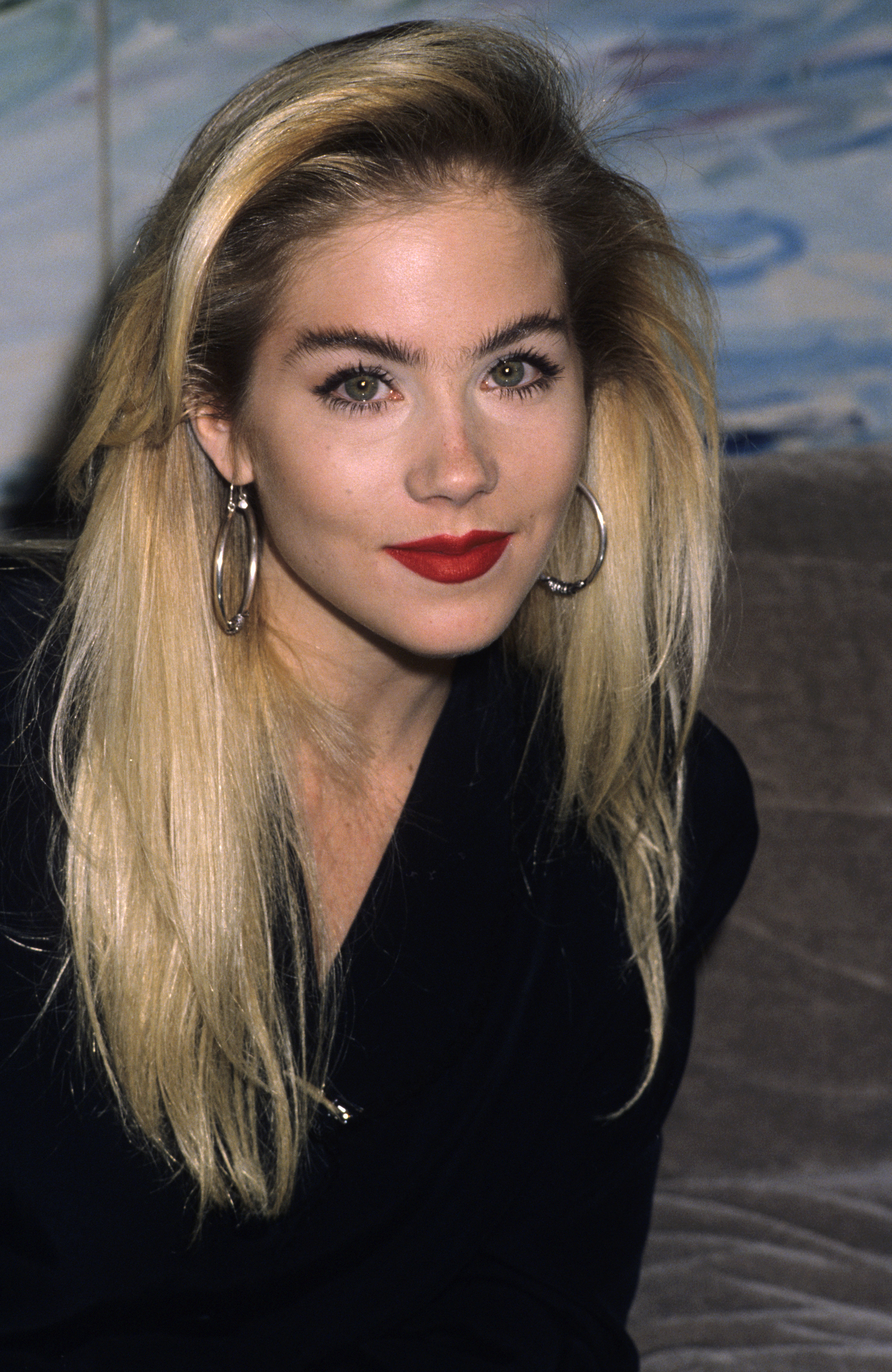Christina Applegate attended the bash to launch The Mondrian Models & Photographers Club on November 17, 1988. The young star looked effortlessly chic in a simple black ensemble, accentuating her signature blonde locks with bold silver hoop earrings, well-defined brows, and a vibrant red lipstick. | Source: Getty Images