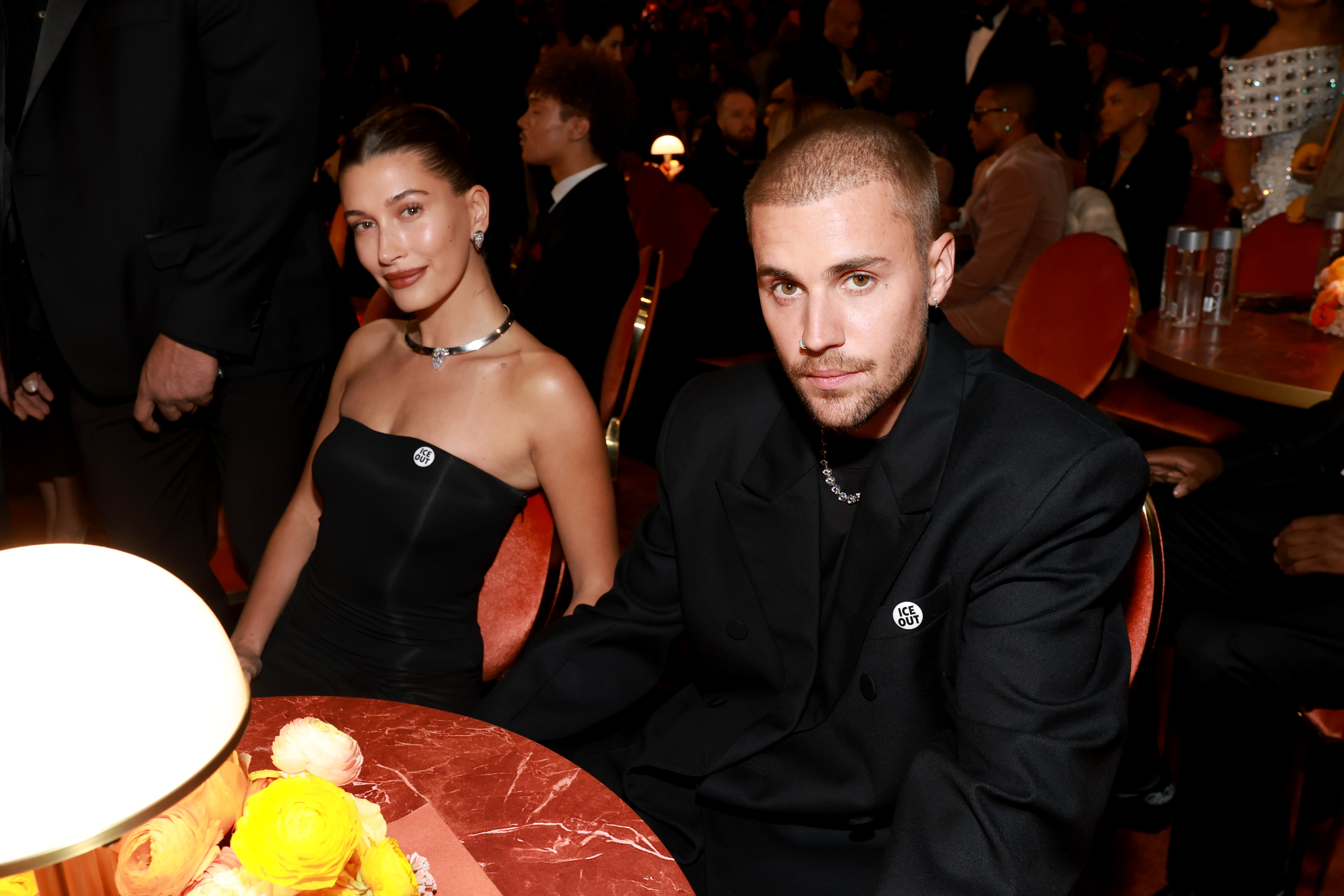 Hailey and Justin Bieber pose together at a table during the 2026 Grammy awards.