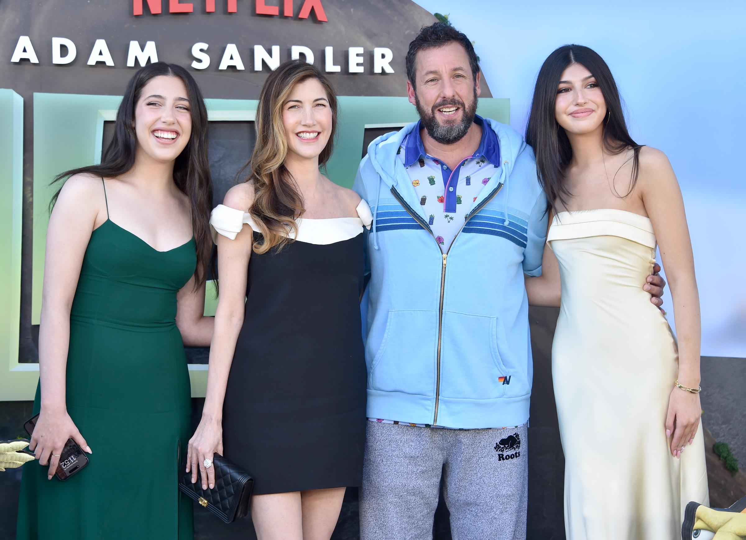 Sadie Sandler, Jackie Sandler, Adam Sandler, and Sunny Sandler pose with red carpet polish and laid-back style. Sadie wears green, Sunny cream, Jackie black, while Adam keeps it casual.