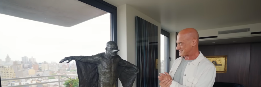 Christopher's art collection is anything but timid, and this winged figure proves it. Displayed at eye level near the windows, it commands as much attention as the skyline outside. | Source: YouTube/Architectural Digest