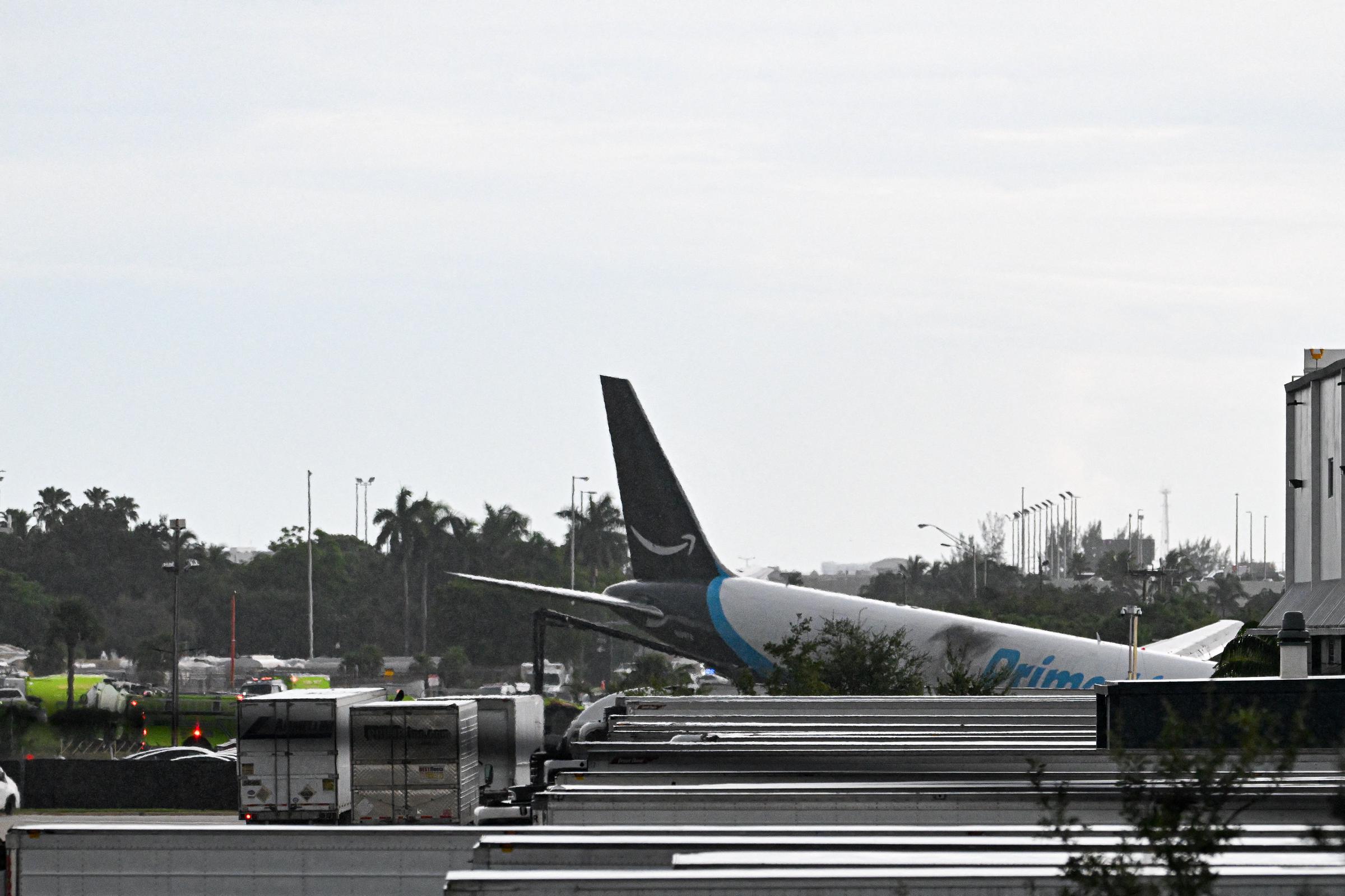 The tail section of the Amazon Air cargo plane is visible after the aircraft overran the runway at Miami International Airport. Investigators are examining why Flight 7598 continued beyond the airport's operational boundary after landing. | Source: Getty Images