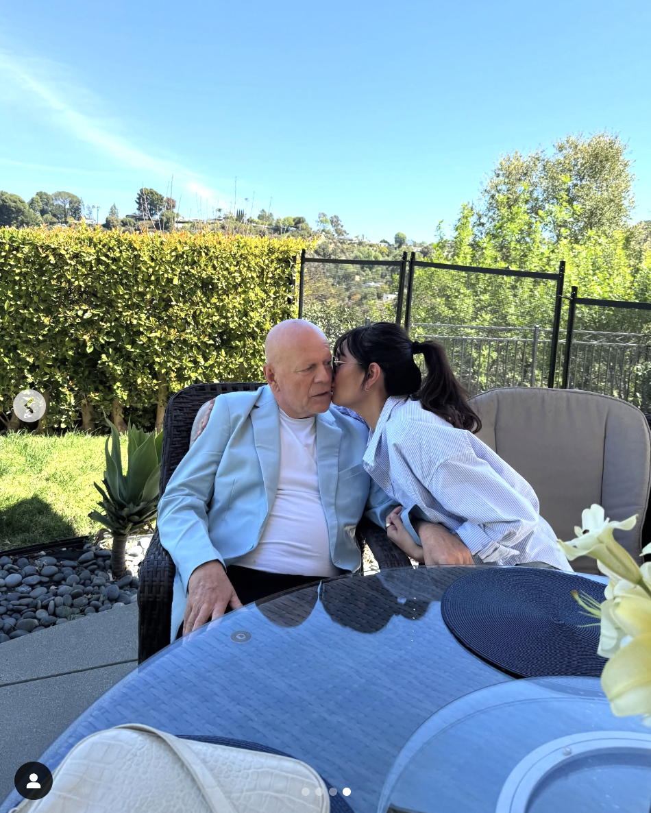 Bruce Willis' wife, Emma Heming, kisses him on the cheek, as seen in a photo shared on March 20, 2025 | Source: Instagram/demimoore