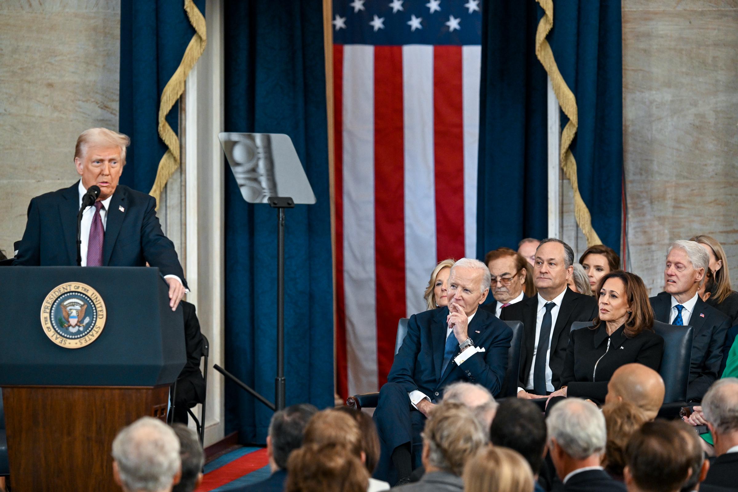 Donald Trump making a speech during his inauguration as Joe Biden, former second gentleman Doug Emhoff, Kamala Harris and former President Bill Clinton listen to him in Washington, D.C., on January 20, 2025. | Source: Getty Images