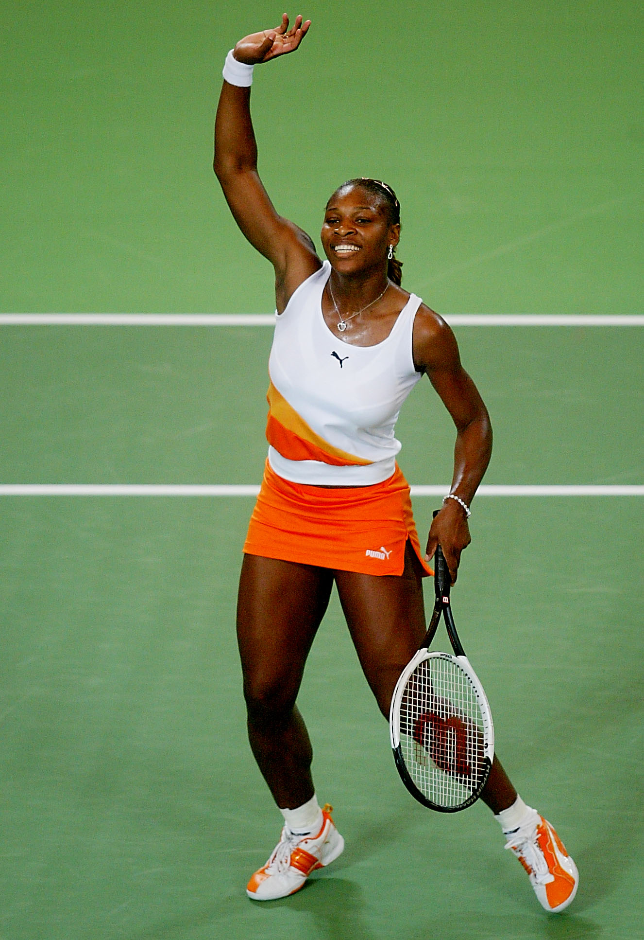 Serena Williams celebrates her victory over Alicia Molik at the Hyundai Hopman Cup held at the Perth Superdome in Perth, Australia. Beaming with a wide smile, she raises her hands in triumph, a joyful testament to a well-fought match.
