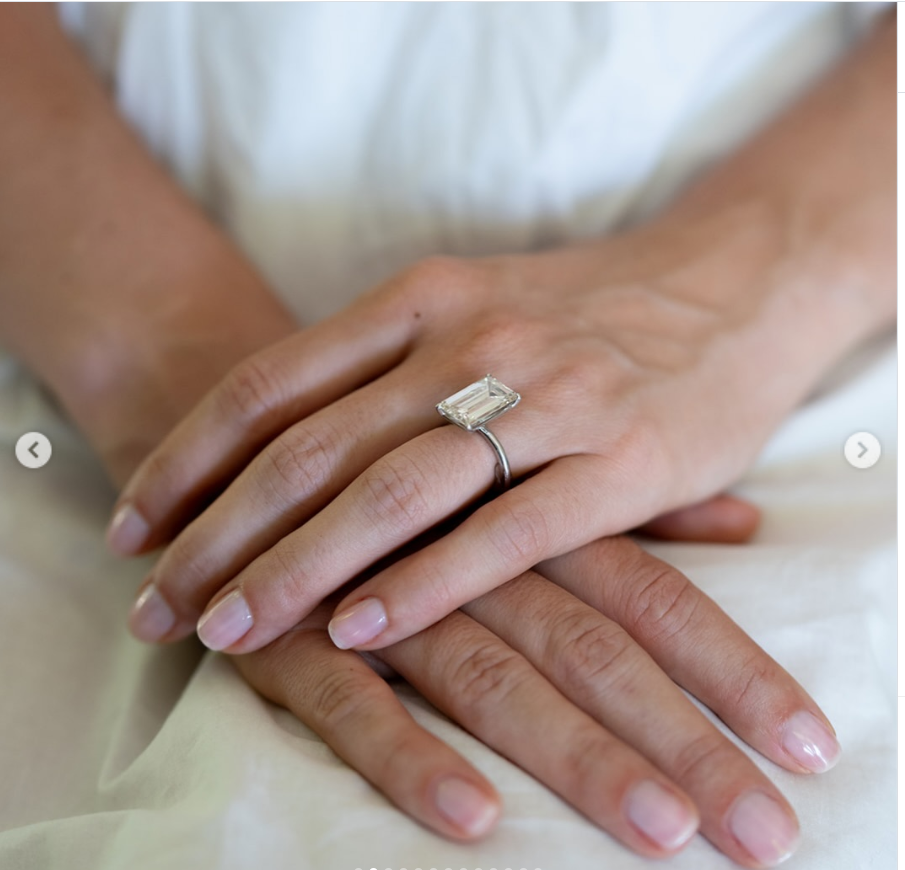 A close-up highlighted Paula’s elegant engagement ring, featuring a rectangular diamond set on a slender band as she gently rested one hand over the other. | Source: Instagram/stonedfinejewelry