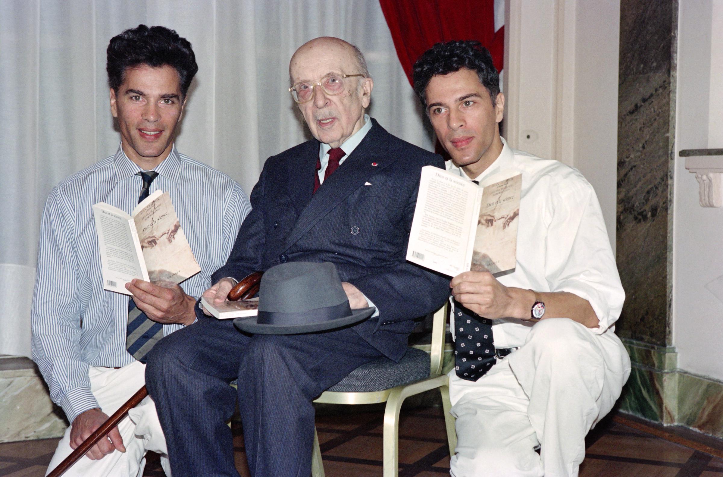 French writer and academician Jean Guitton (center) is pictured with French scientific journalists Igor (left) and Grichka Bogdanoff (right), his co-authors of "Dieu et la Science," in Paris. The twins appear refined and youthful, their defined cheekbones accentuating their handsome features.