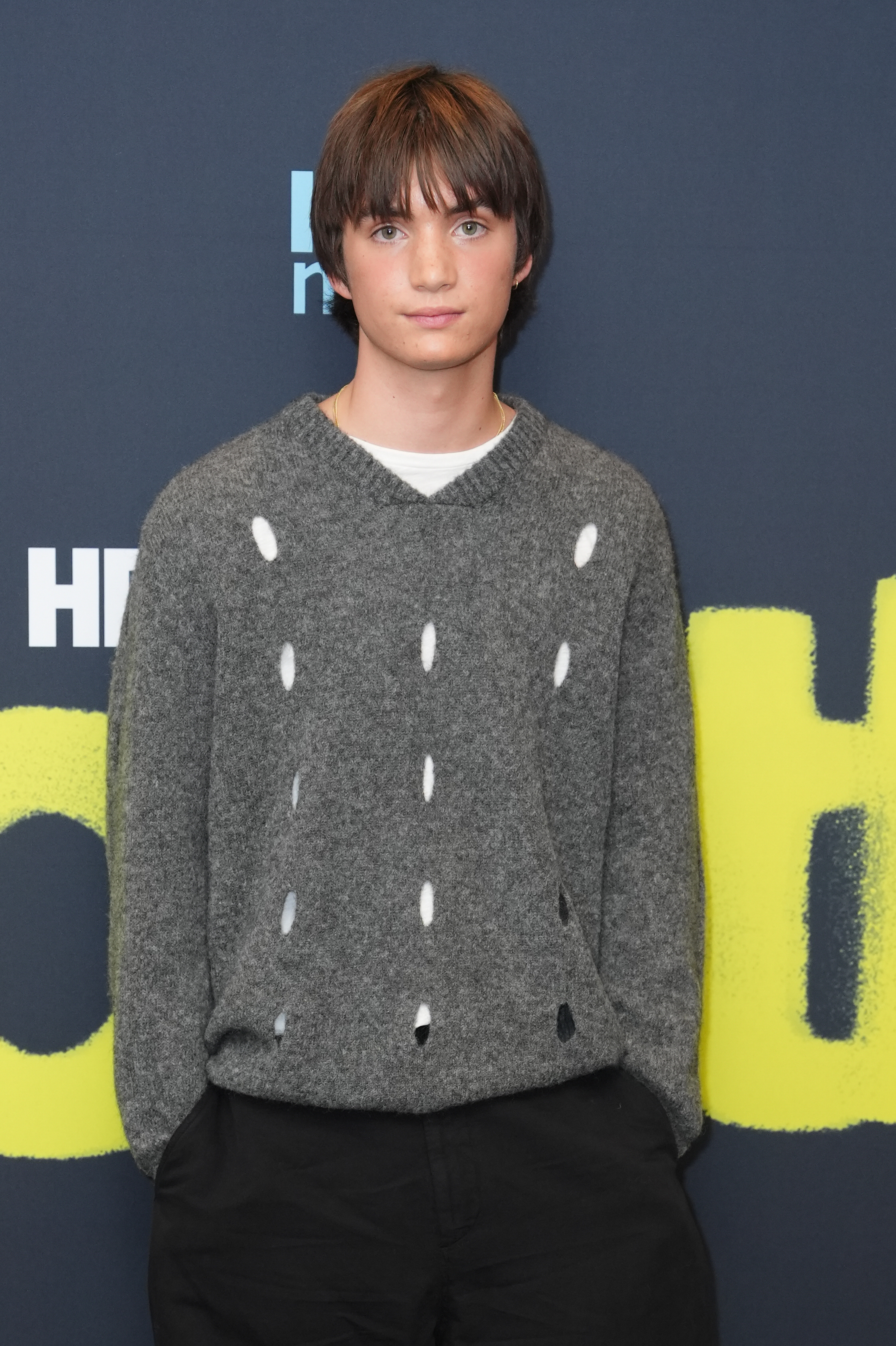 For the UK special screening of Youth, Aran chose a distressed gray knit, black jeans, and a gold chain rather than traditional formal tailoring. — Aran has said that the anxiety and uncertainty facing his 18-year-old Youth character felt familiar from his own life at the same age. | Getty Images