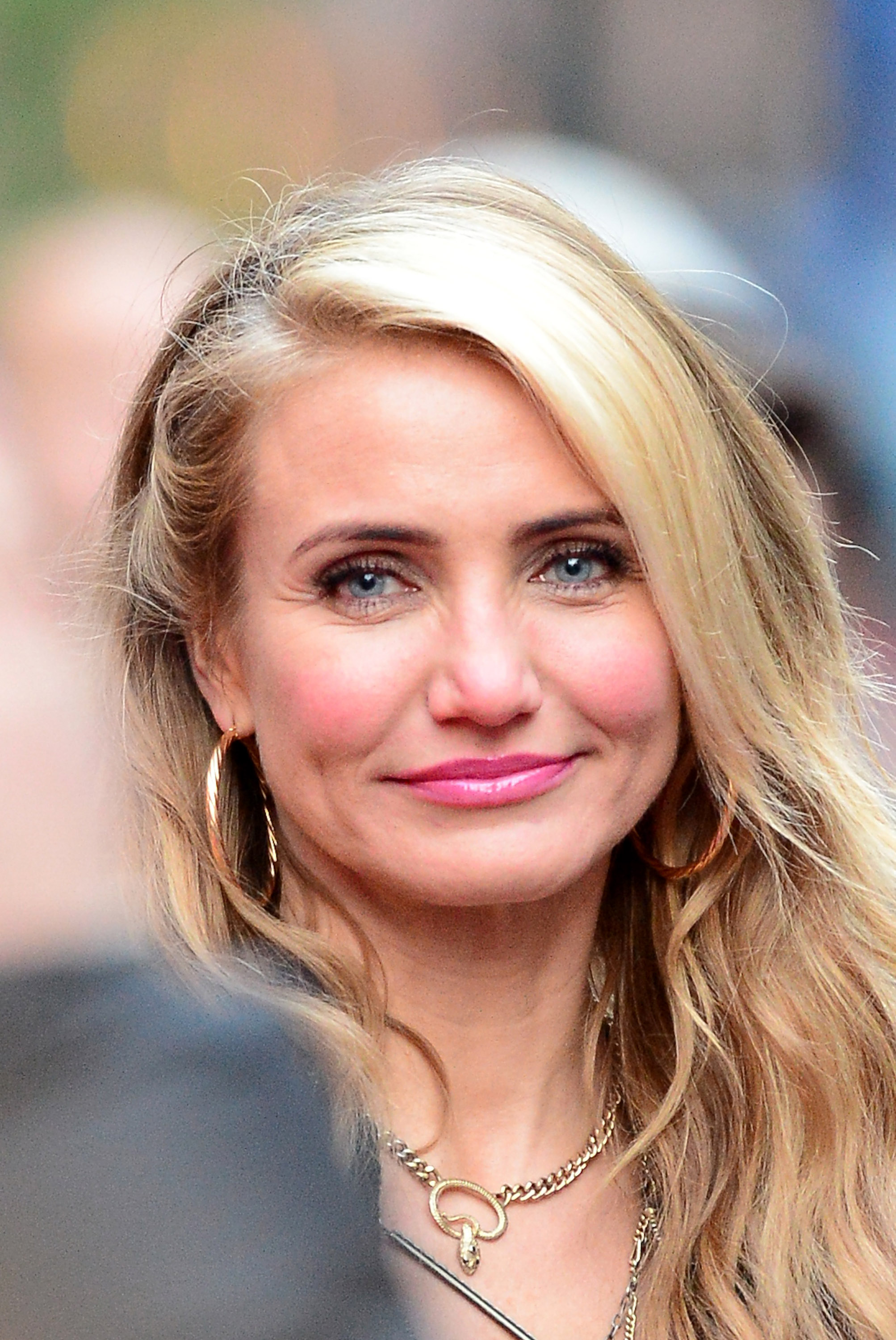 Cameron Diaz is seen on the set of “Anna,” wearing natural makeup with soft pink tones, her blonde hair styled in loose waves, and accessorized with gold hoop earrings
