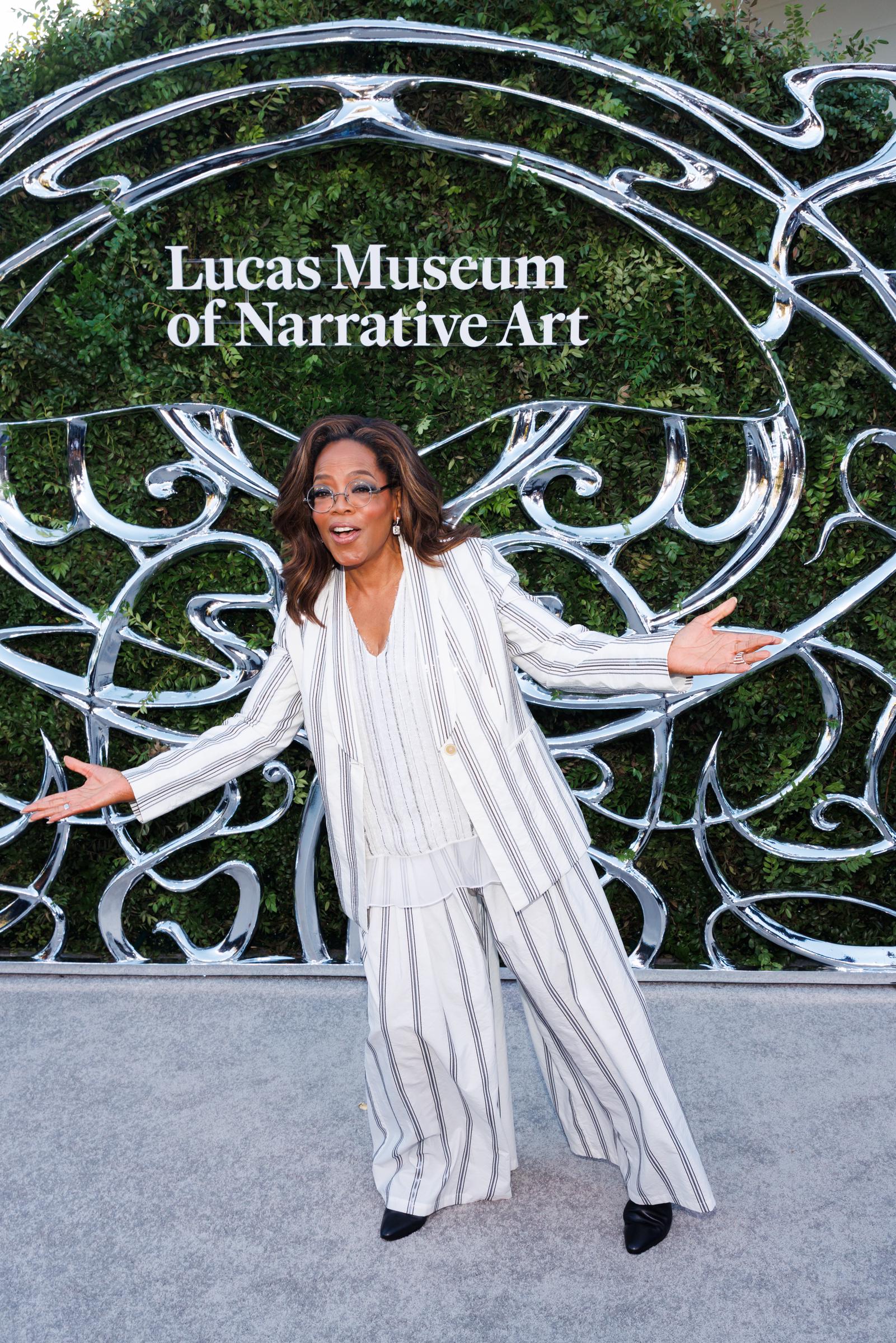 Winfrey switched up her pose for another photograph, throwing her arms wide in front of the Lucas Museum backdrop. The playful moment showed another side of her opening-night appearance. | Source: Getty Images