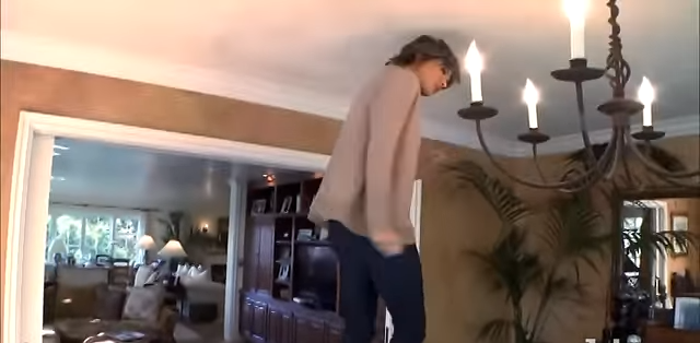 Standing near the ceiling, Rinna shows off the solid construction of the antique table originally built to show horses. | Source: YouTube/@Biography