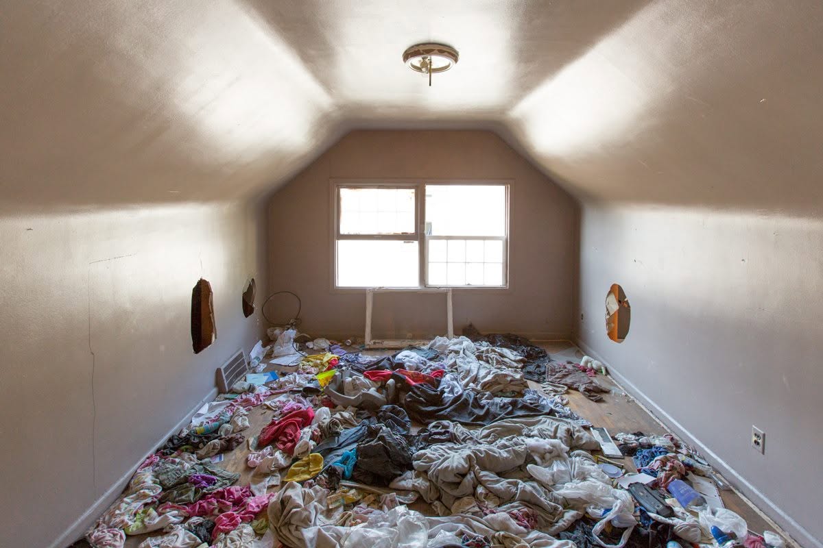 Clothes and debris covered the floor of what had once been a bedroom, illustrating how dramatically the property had changed since Eminem's childhood. Soon after these photographs were taken, the house was demolished. | Source: Facebook/eminem