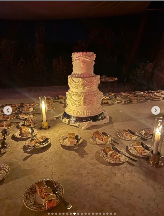 The towering wedding cake took center stage after dark, surrounded by neatly plated slices and glowing candlelight that gave the dessert table an intimate atmosphere. | Source: Instagram/babybruss
