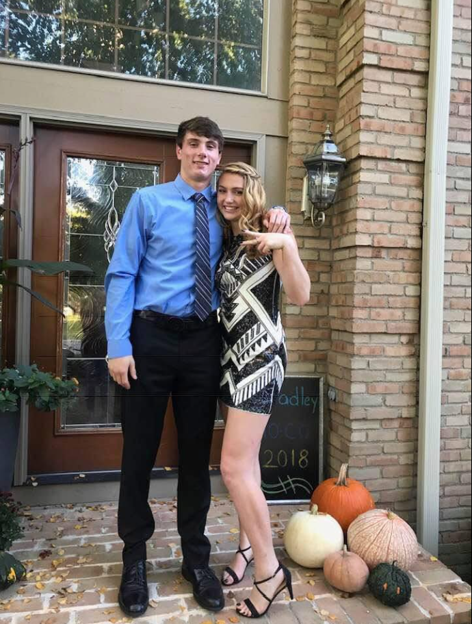 Standing at a front doorstep framed by brick and autumn décor, Jack Pugh and Kenna Lyn McClelland pose with a quiet kind of pride and excitement. | Source: Facebook/KennaLynMcClelland