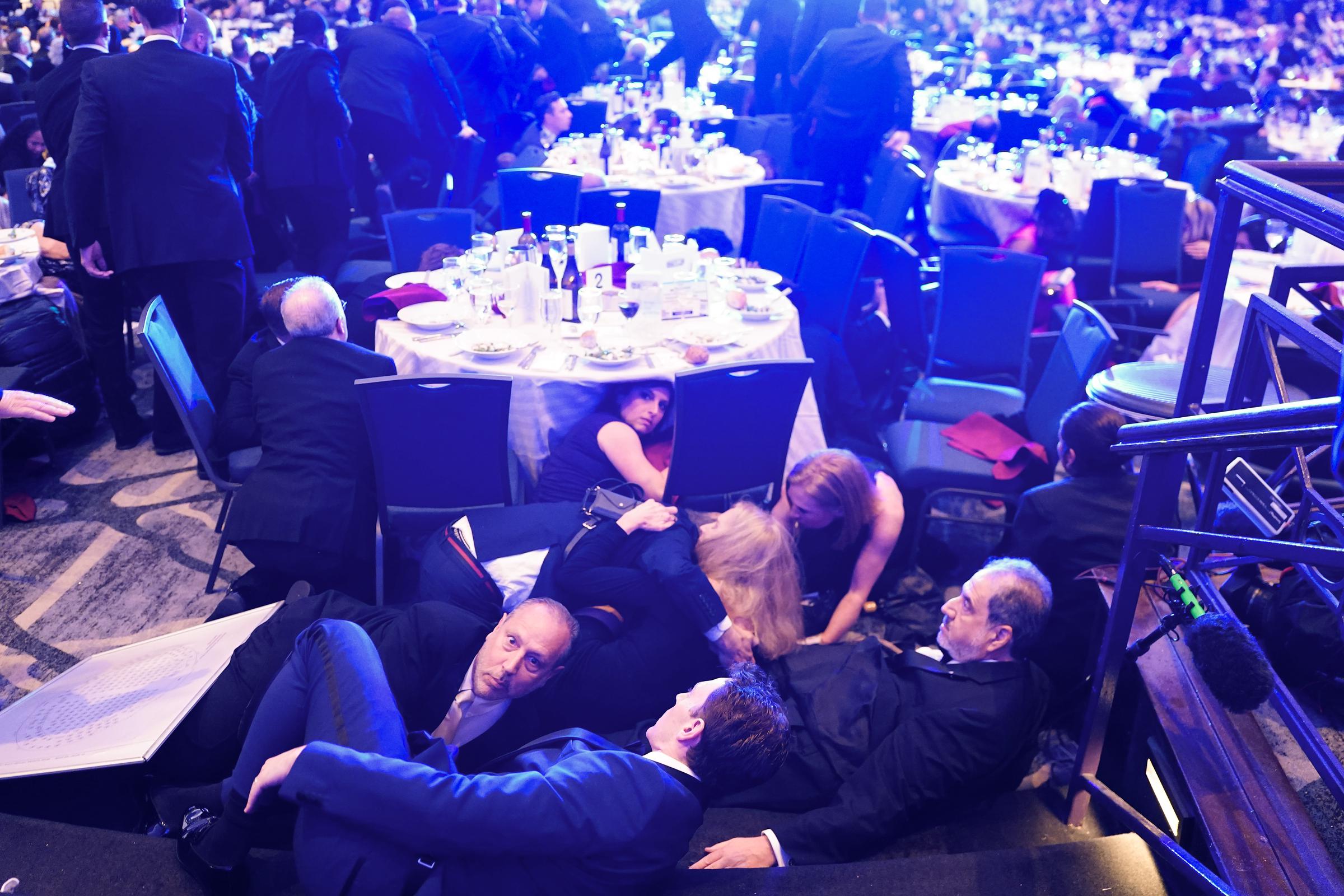 People take cover after an incident at the annual White House Correspondents Association Dinner in Washington, DC on April 25, 2026. | Source: Getty Images