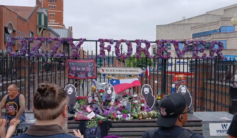 Fans continued leaving flowers, messages, and personal tributes at Black Sabbath Bridge as Birmingham marked the first anniversary of Ozzy Osbourne's death. The memorial reflected the lasting connection Sharon said her husband always felt with his hometown. | Source: Instagram/bhamcitycouncil