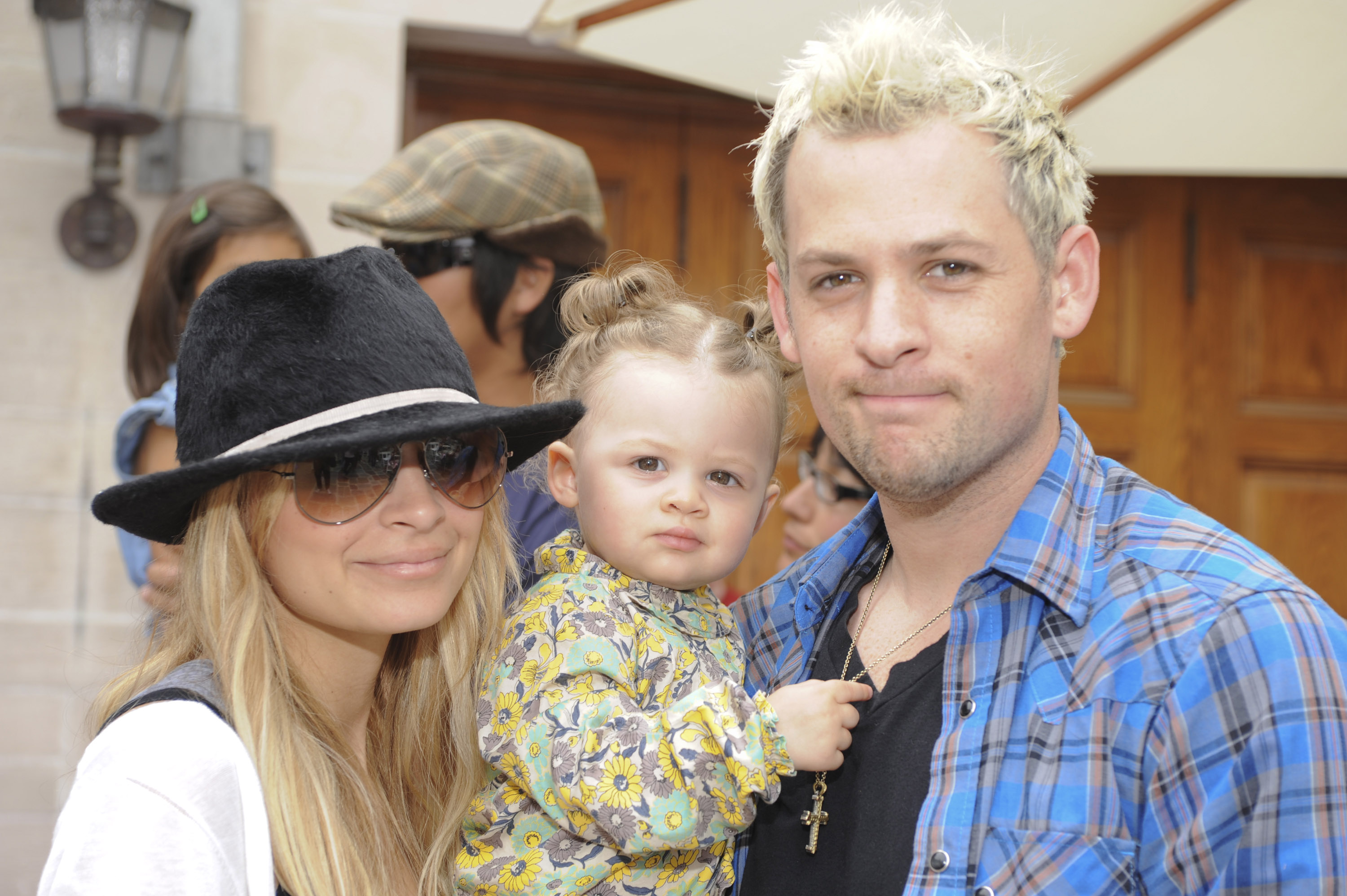 Nicole Richie stands beside Joel Madden while holding Harlow Winter Kate Madden at the 3rd Annual Kidstock Music and Arts Festival in Beverly Hills in May 2009. Kate looks toward the camera in a printed outfit as her parents pose closely beside her.