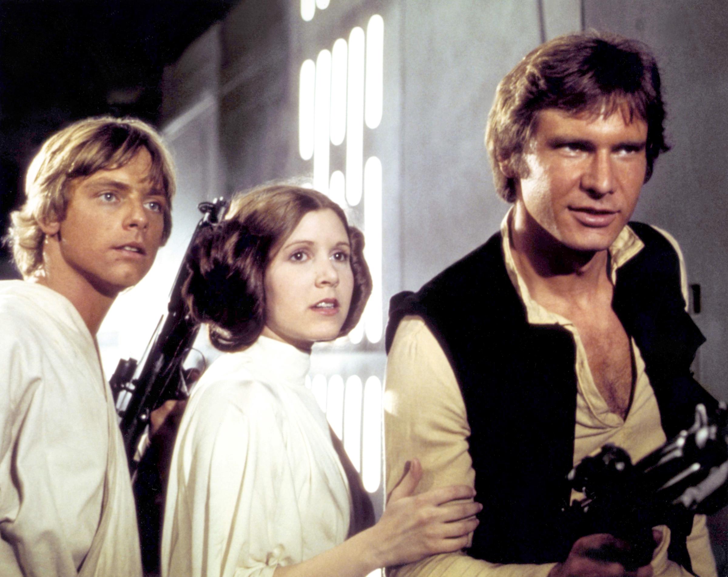 Mark Hamill appeared with Carrie Fisher and Harrison Ford as Luke Skywalker, Princess Leia, and Han Solo on the set of "Star Wars: A New Hope." The trio was photographed in costume during production of George Lucas's space epic, which introduced their characters to moviegoers. Hamill's appearance here provided another look at the actor before his January 1977 crash fractured his nose and left cheekbone, requiring reconstructive treatment.
