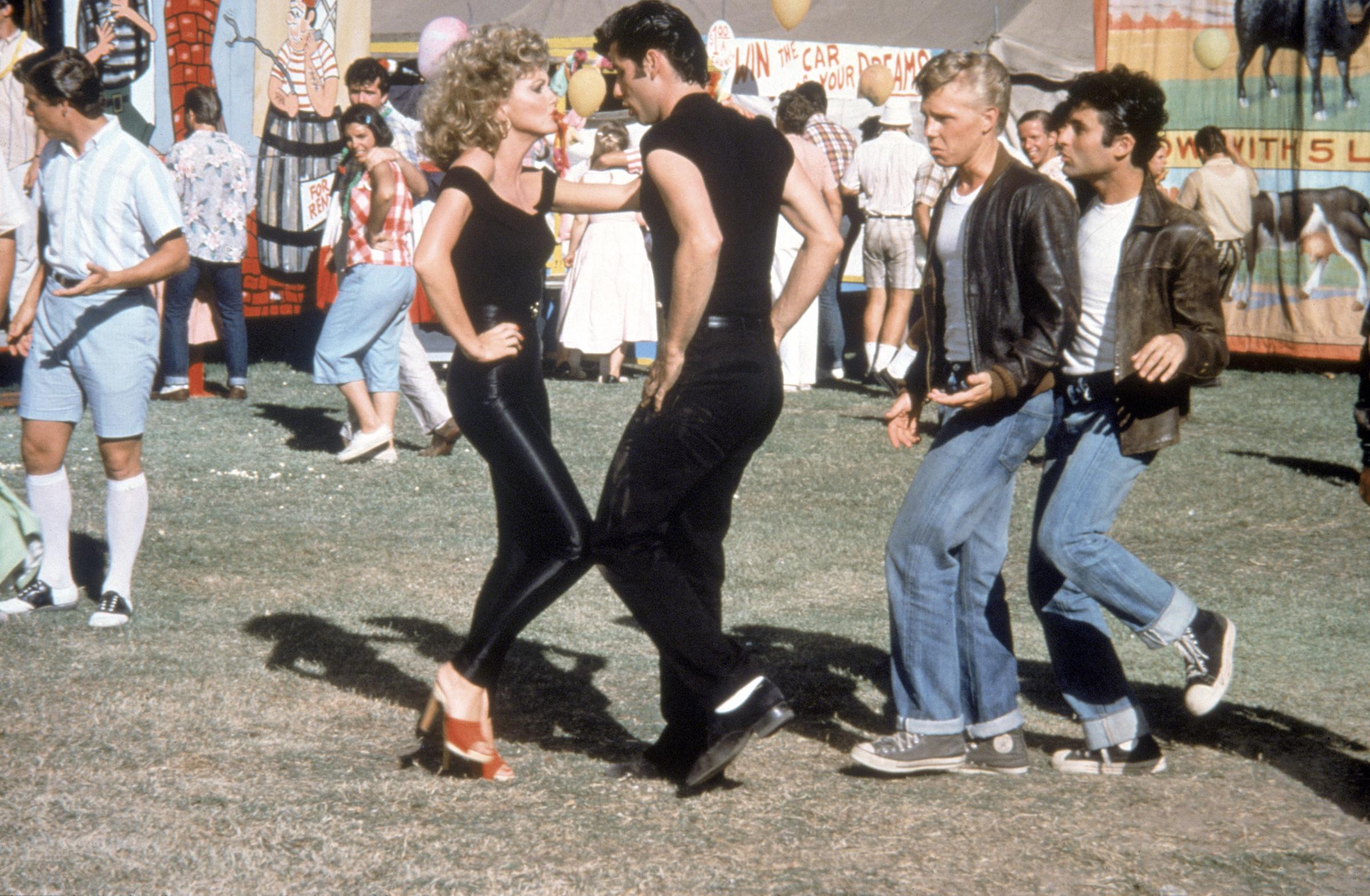 Sandy and Danny dancing together as their fellow high school classmates watch them. | Source: Getty Images
