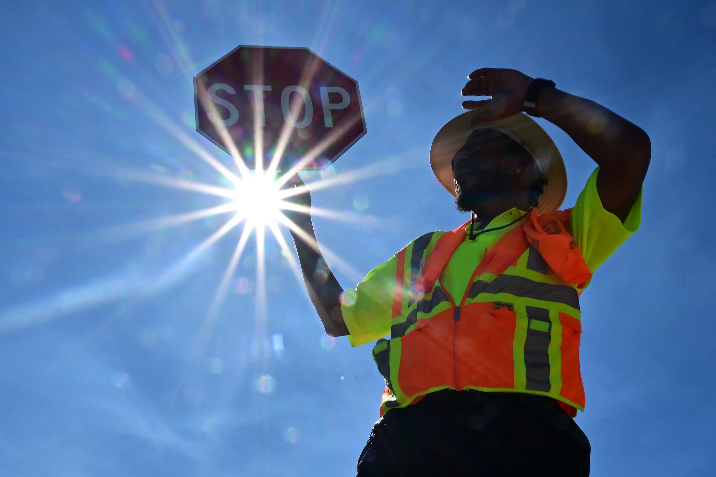 A traffic warden shields his face from the intense sun while working a shift in Las Vegas, Nevada, during a heatwave on July 12, 2023 | Source: Getty Images