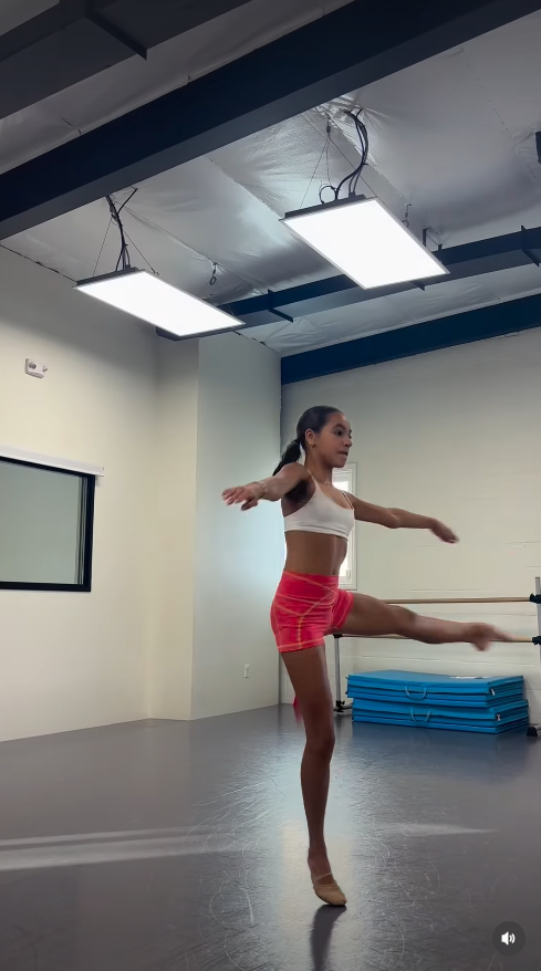Fiona Lowe practices ballet in a dance studio, balancing on one foot as she extends her leg during a routine. The image captures the teenager’s dedication to dance, a passion that remained part of her life in the months before her death. | Source: Instagram/fiona.lowe.dances