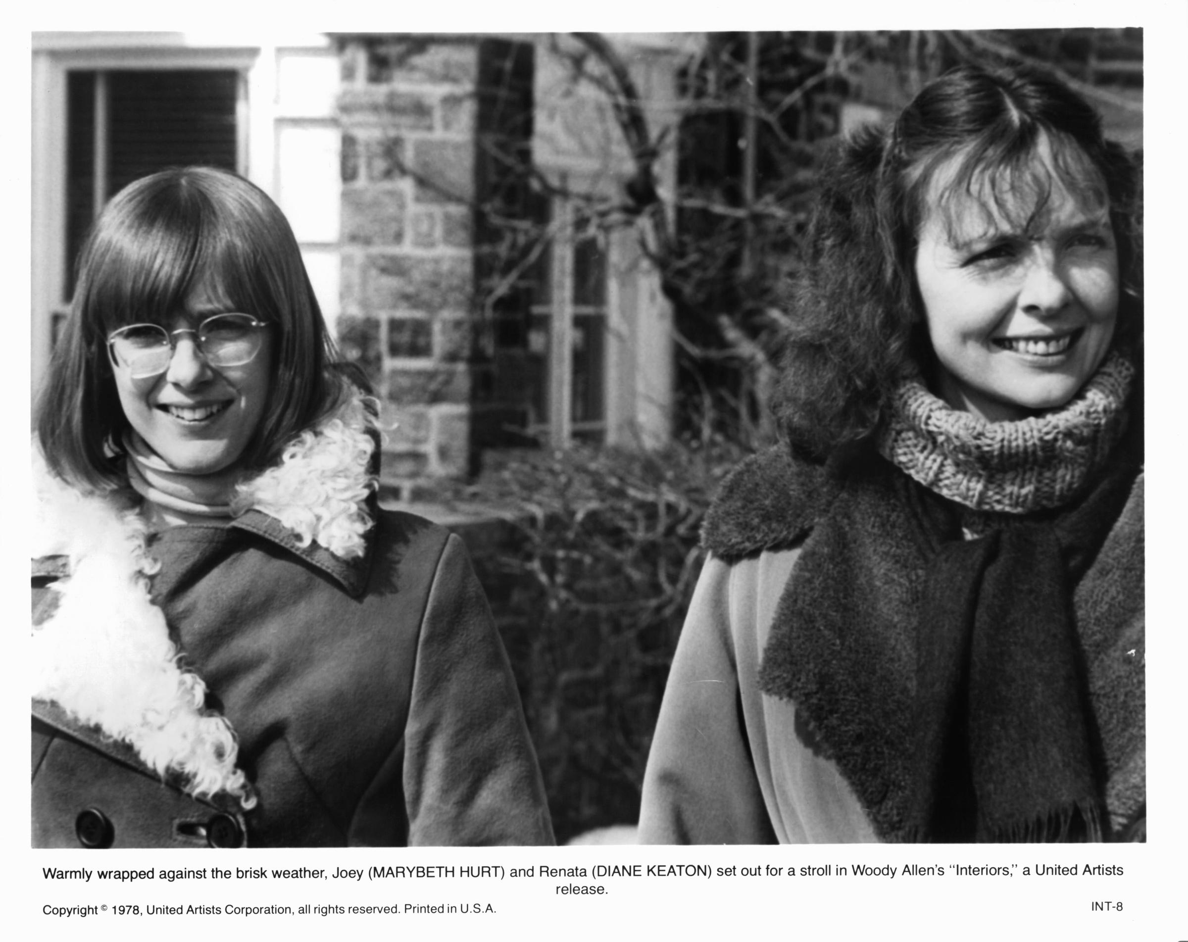 Mary Beth Hurt and Diane Keaton stand outdoors in heavy winter coats, smiling in a stark scene from "Interiors" in 1978.