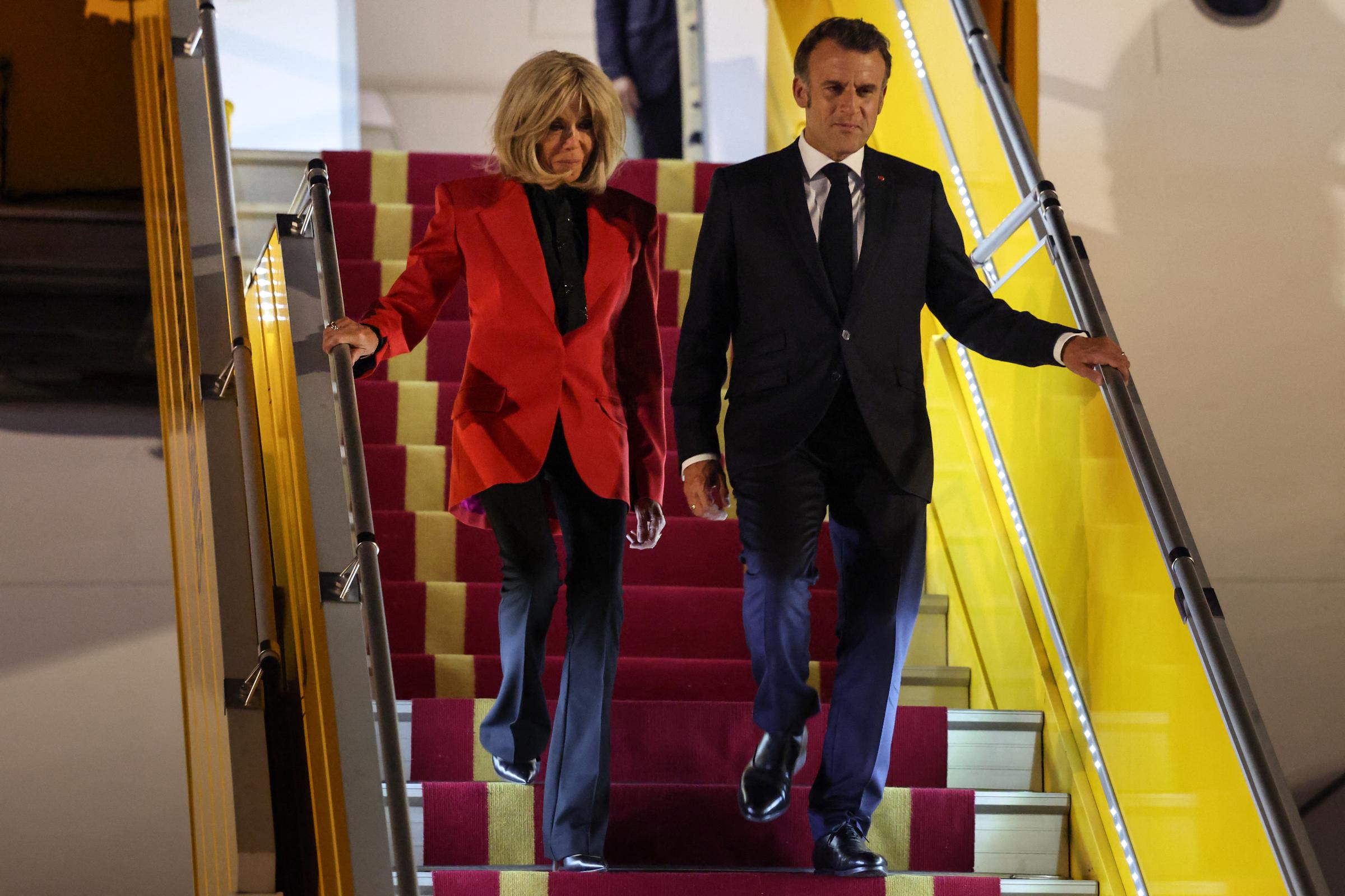 Brigitte and Emmanuel Macron walking down the aircraft steps. | Source: Getty Images