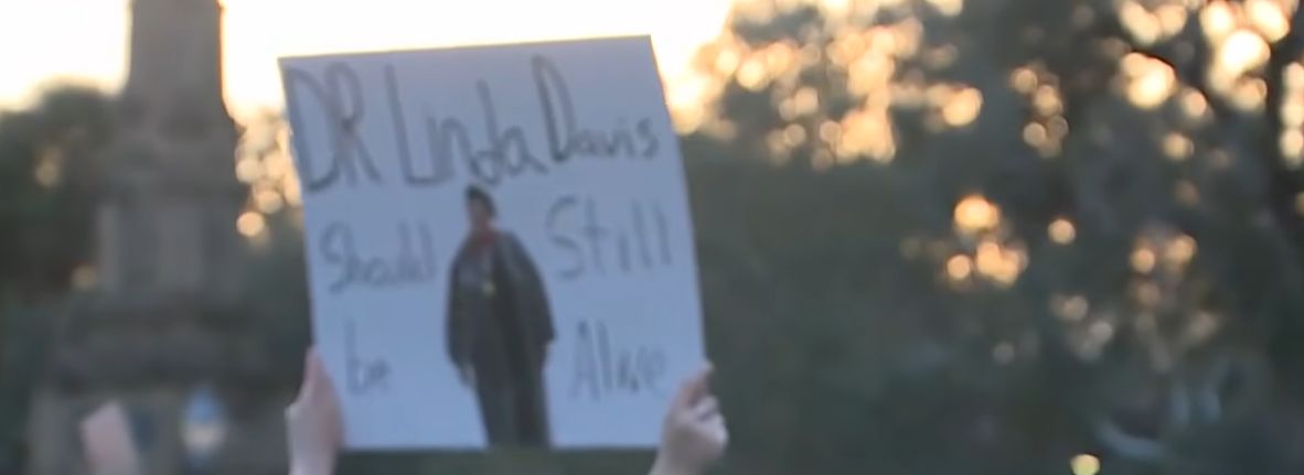 During the protest outside Forsyth Park, the sign can be read, from a post dated  February 18, 2026. | Source: YouTube/WJCLNews