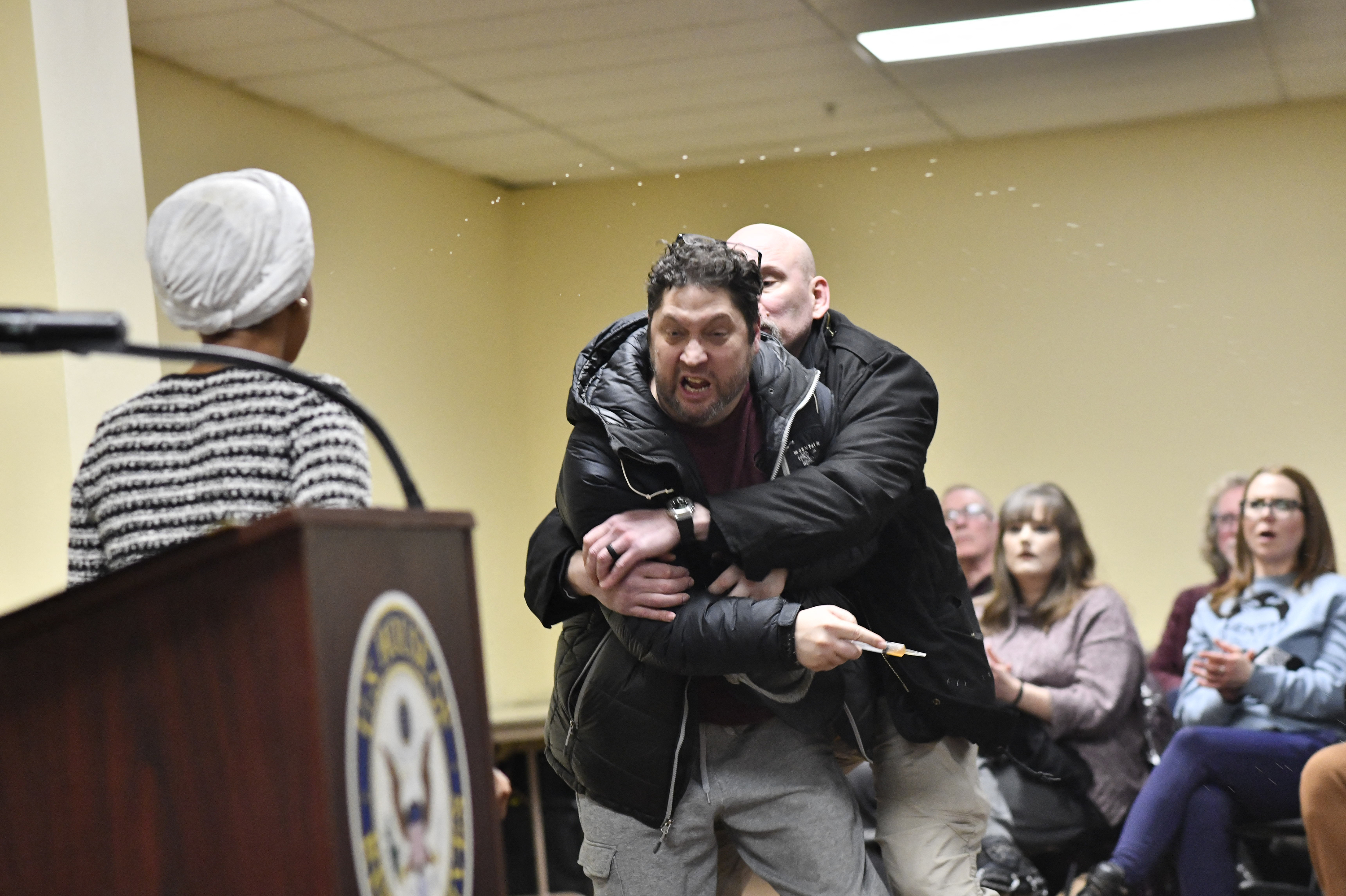 Anthony J. Kazmierczak is tackled after lunging at Ilhan Omar on January 27, 2026 | Source: Getty Images