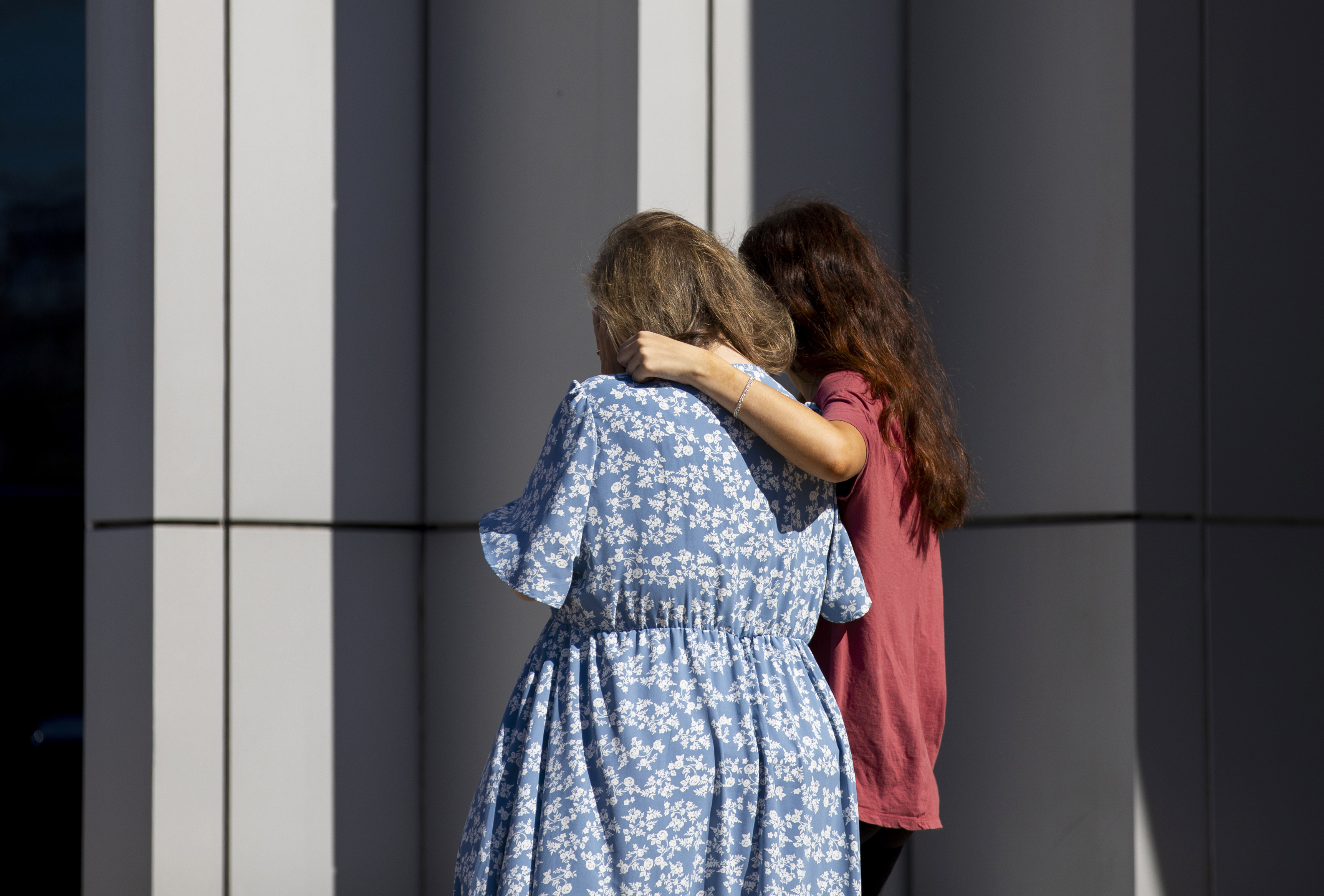 A woman and her daughter console each other as church members and residents reunite at Trillium Theater located across the street from the site of a shooting and fire at the Church of Jesus Christ of Latter-day Saints on September 28, 2025, in Grand Blanc, Michigan. | Source: Getty Images