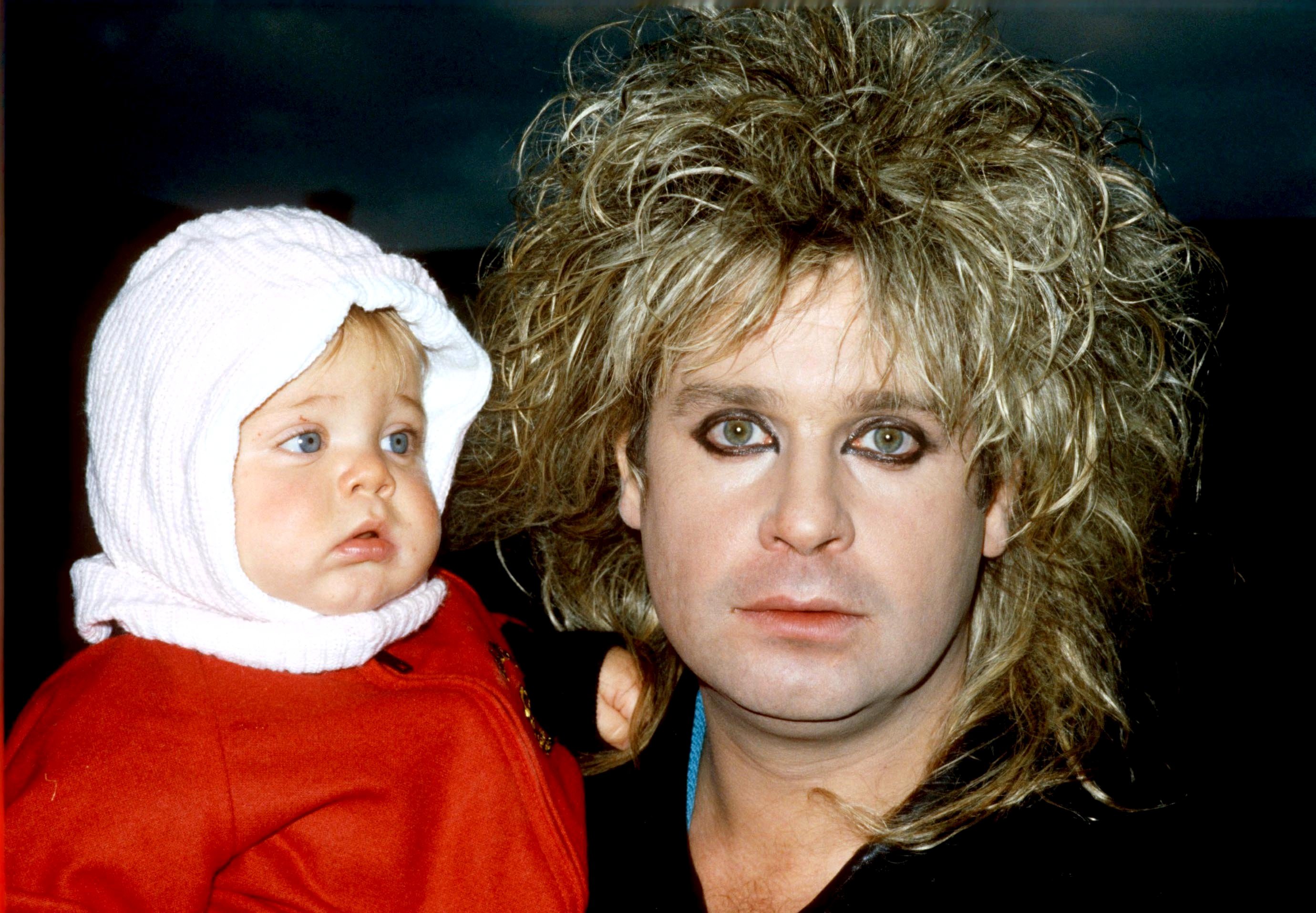 Ozzy Osbourne holds daughter Kelly Osbourne during her early childhood, showcasing the close bond that would later become familiar to fans through the family's years in the spotlight. | Source: Getty Images