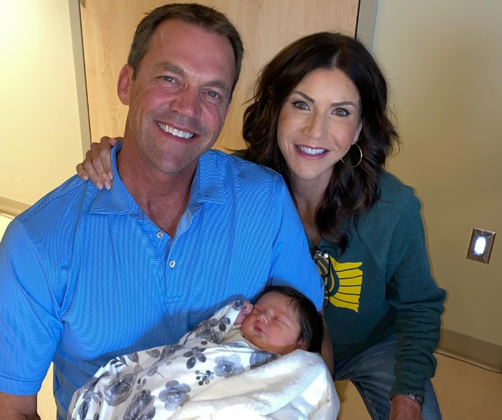 Seated with a newborn cradled between them, Kristi and Bryon smile softly—pride, tenderness, and a deeply personal family moment captured in stillness. | Source: Instagram/sdbryonnoem