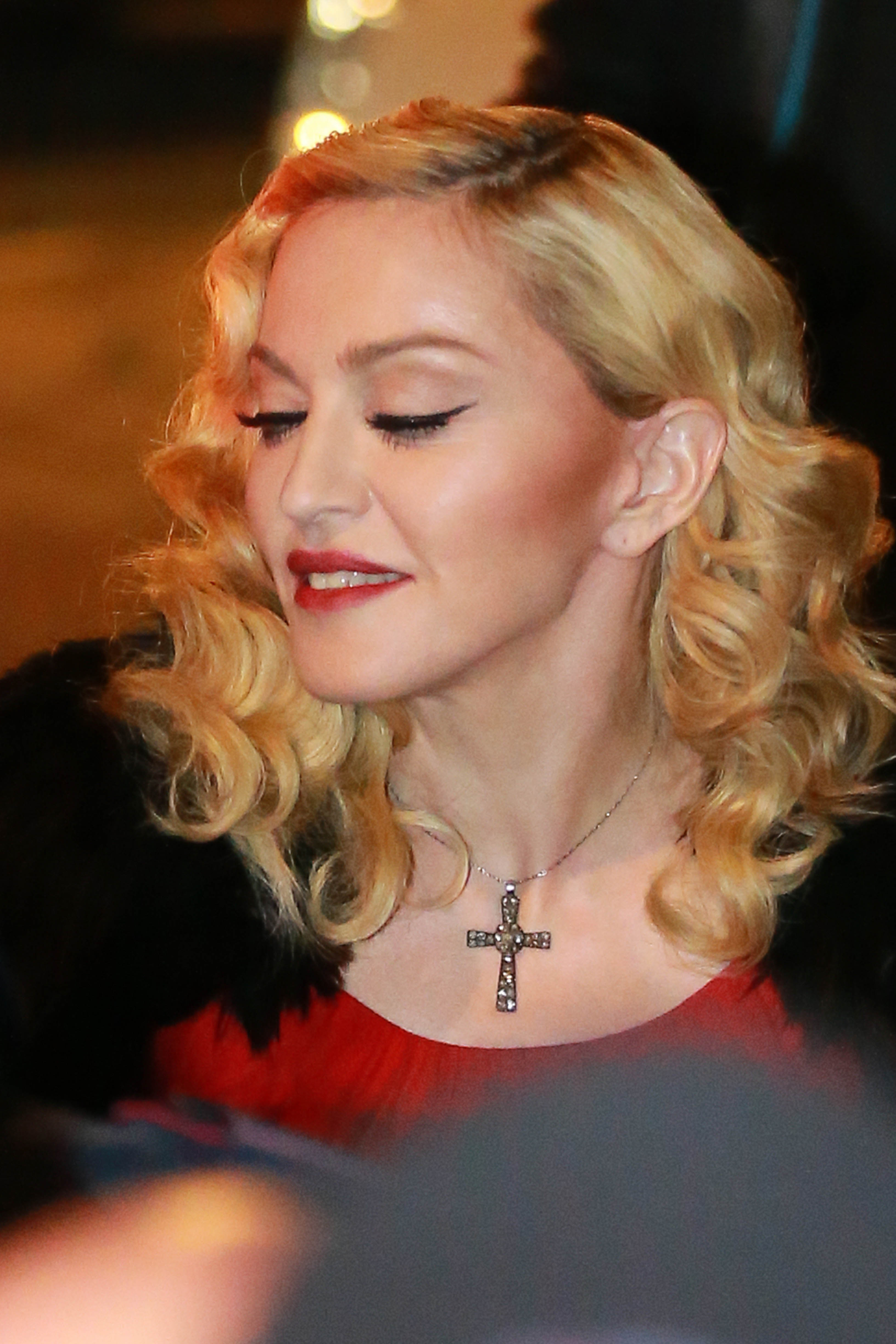 Madonna arrives in Milan on March 1, 2015, while promoting her album "Rebel Heart." She was photographed with curled blond hair and red lipstick during the promotional appearance. | Source: Getty Images