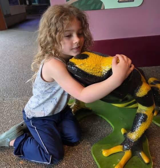 Rhoam Summer, 5, hugs a colorful frog statue, a sweet moment reflecting the little boy's love for animals of all kinds. | Source: Facebook/Cape Cod Women for Change