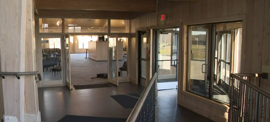 Glass doors and broad windows filled this renovated passageway with natural light, replacing the neglected atmosphere visible throughout Mike Tyson's former mansion before its transformation. Railings bordered the walkway as it opened toward another furnished section of the church, showing how existing architectural elements were incorporated into a brighter, more accessible interior designed to accommodate people moving throughout the expansive religious campus. | Source: YouTube/WKYC Channel 3
